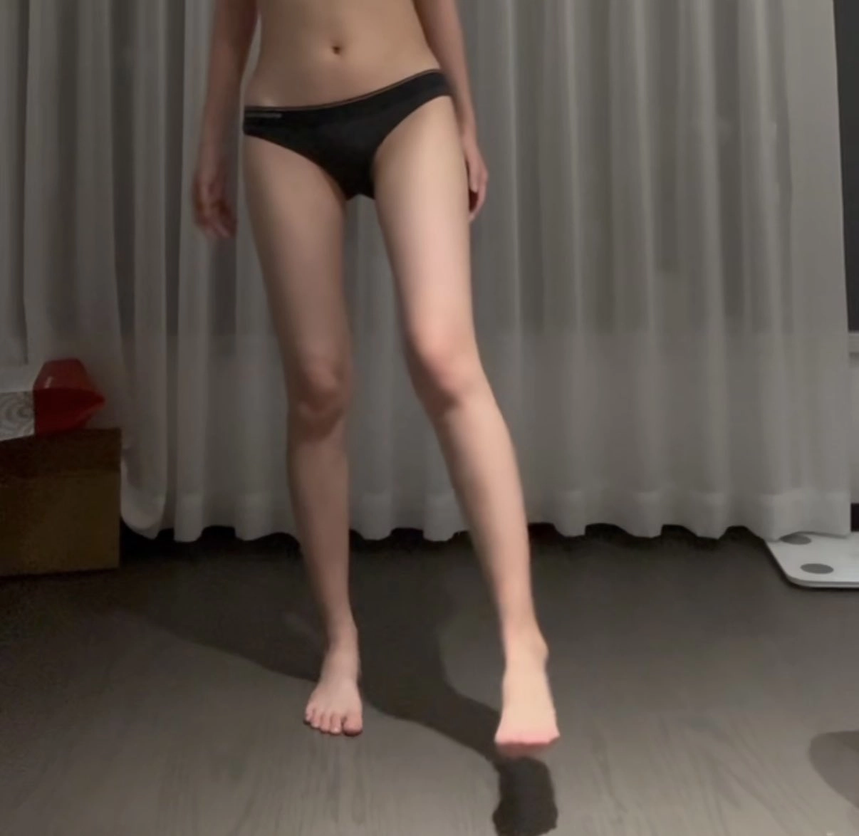 穿比基尼的女人穿过一间房间。