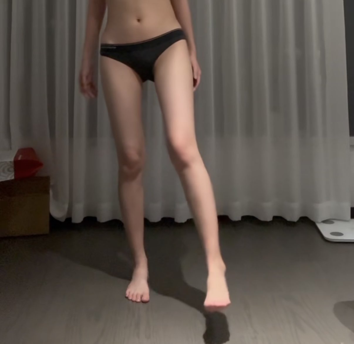 穿比基尼的女人穿过一间房间。