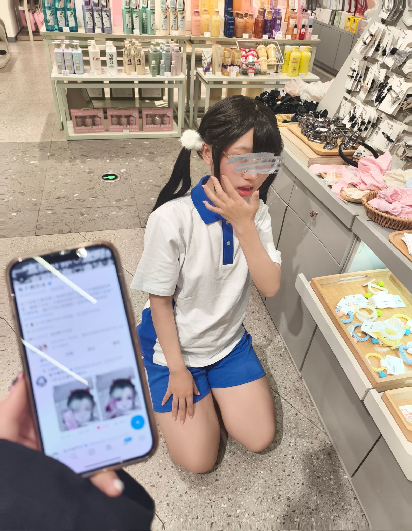 女孩跪在手机前面。