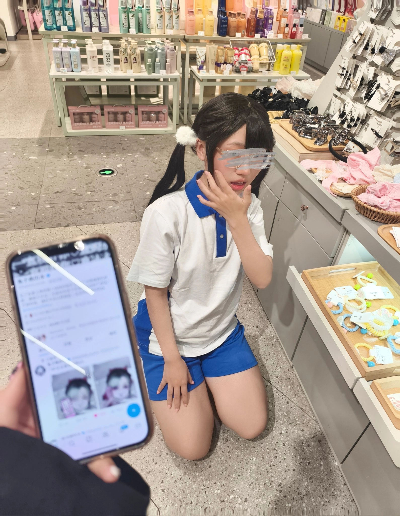 女孩跪在手机前面。