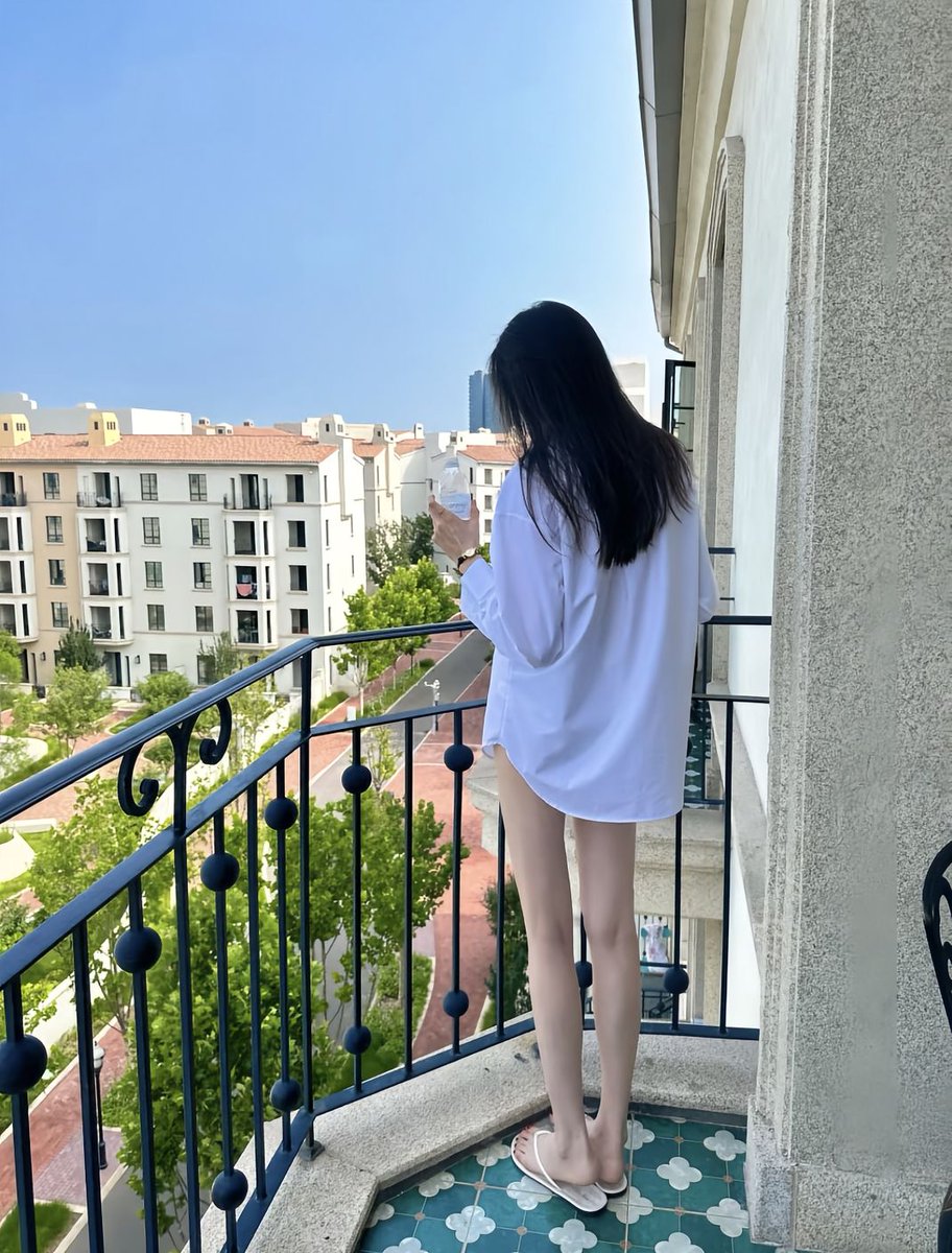 穿着白色衬衫的女人从杯子里喝酒。