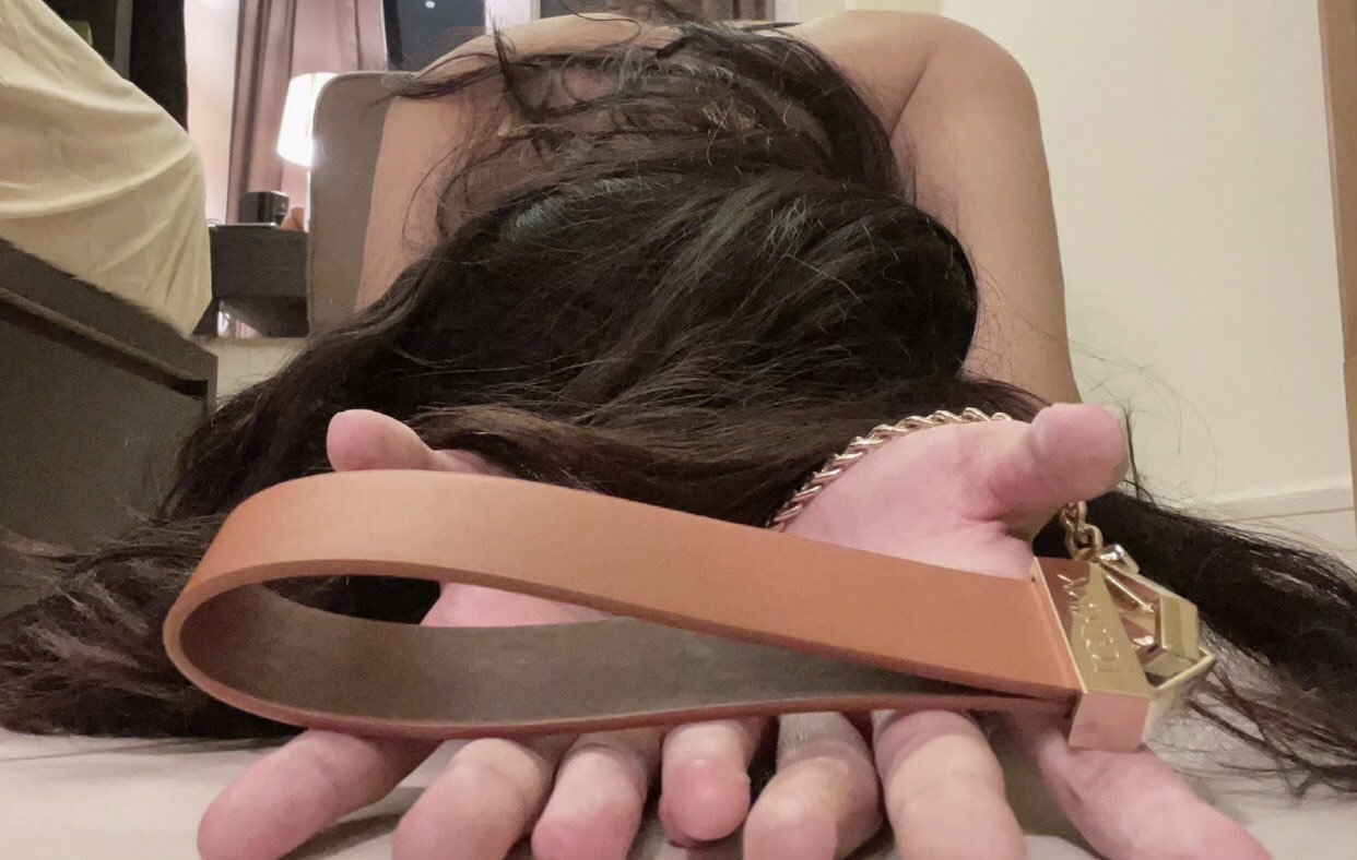 女人躺在地板上,手腕周围有一条皮带。