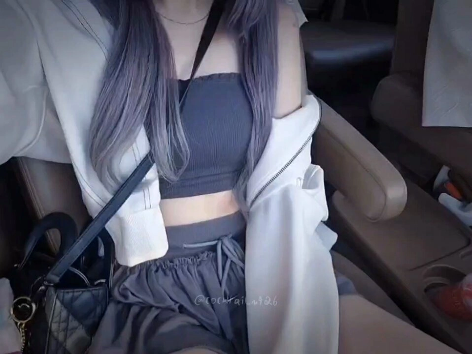 一位女人穿着灰色的衬衫和短裤,带有黑色绳索。