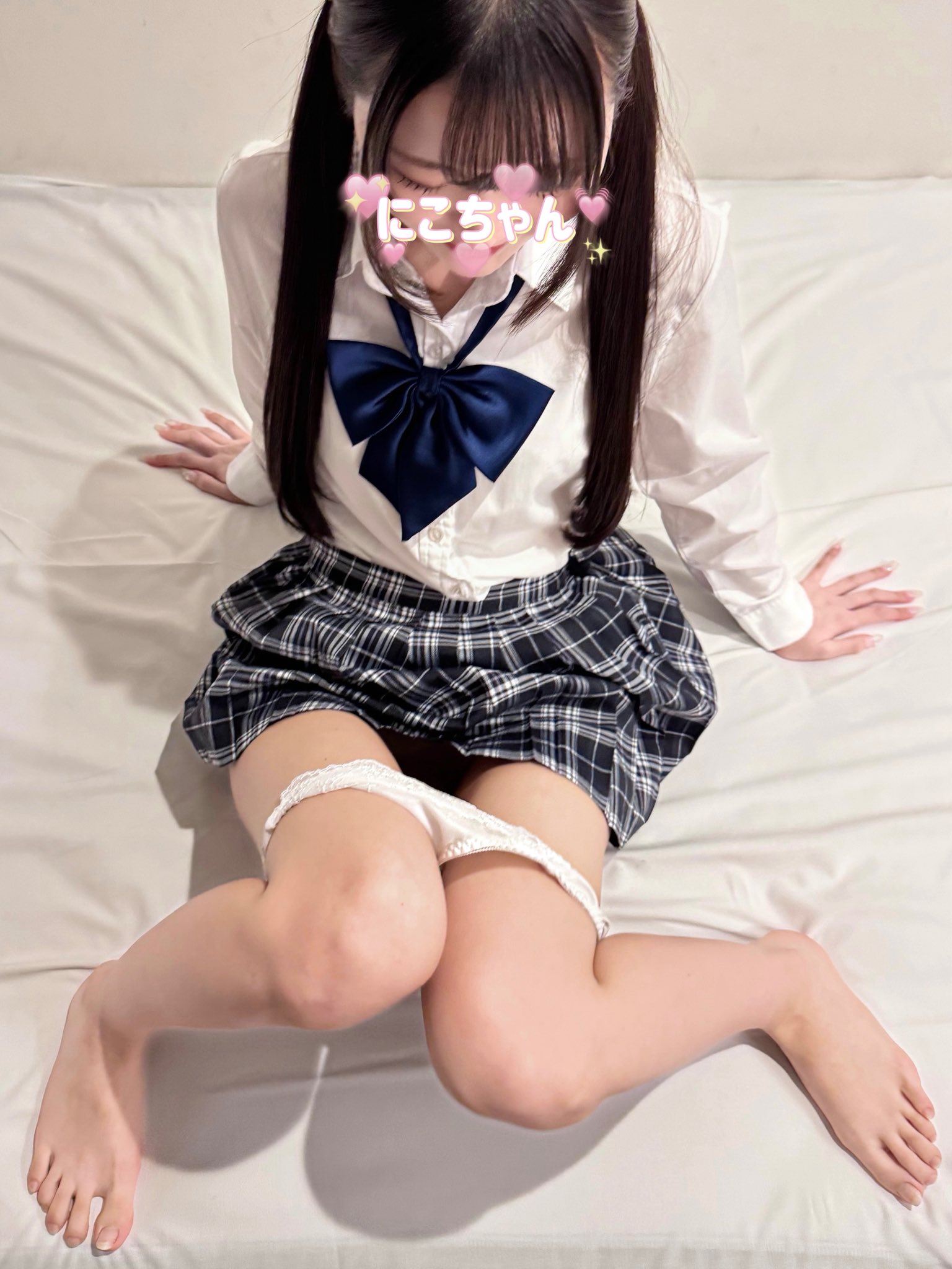 头发上有弓的女孩坐在床上。