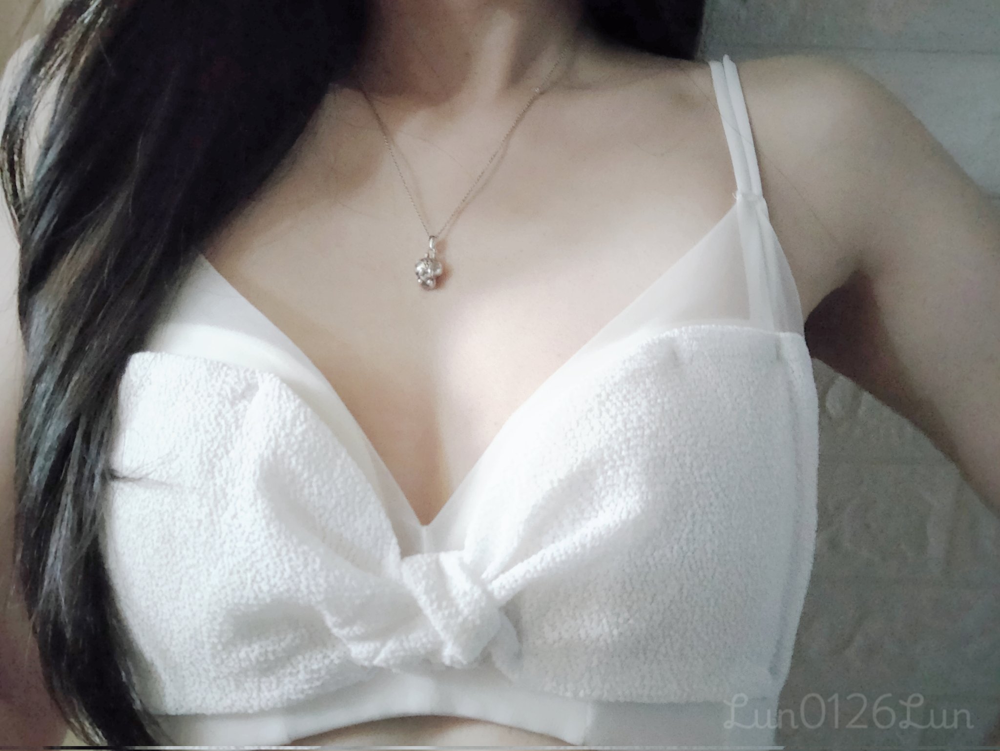 女人穿着一个白色的胸罩与一个弓。