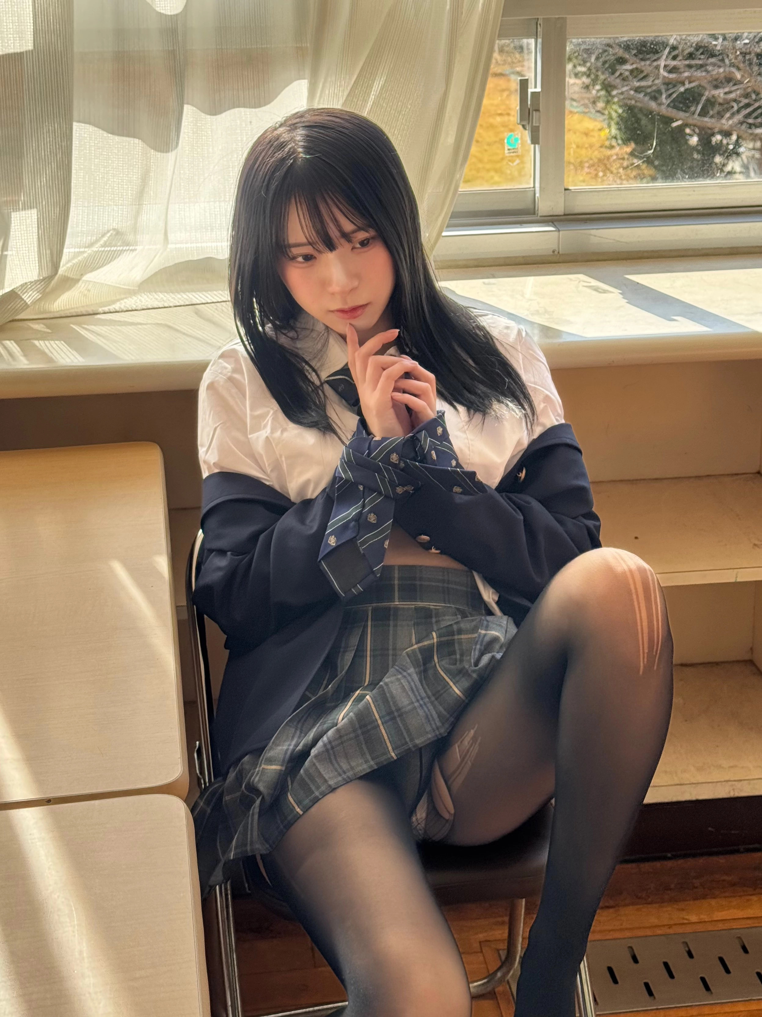 穿着白色衬衫和黑色衬衫的女人坐在一个凳子上。