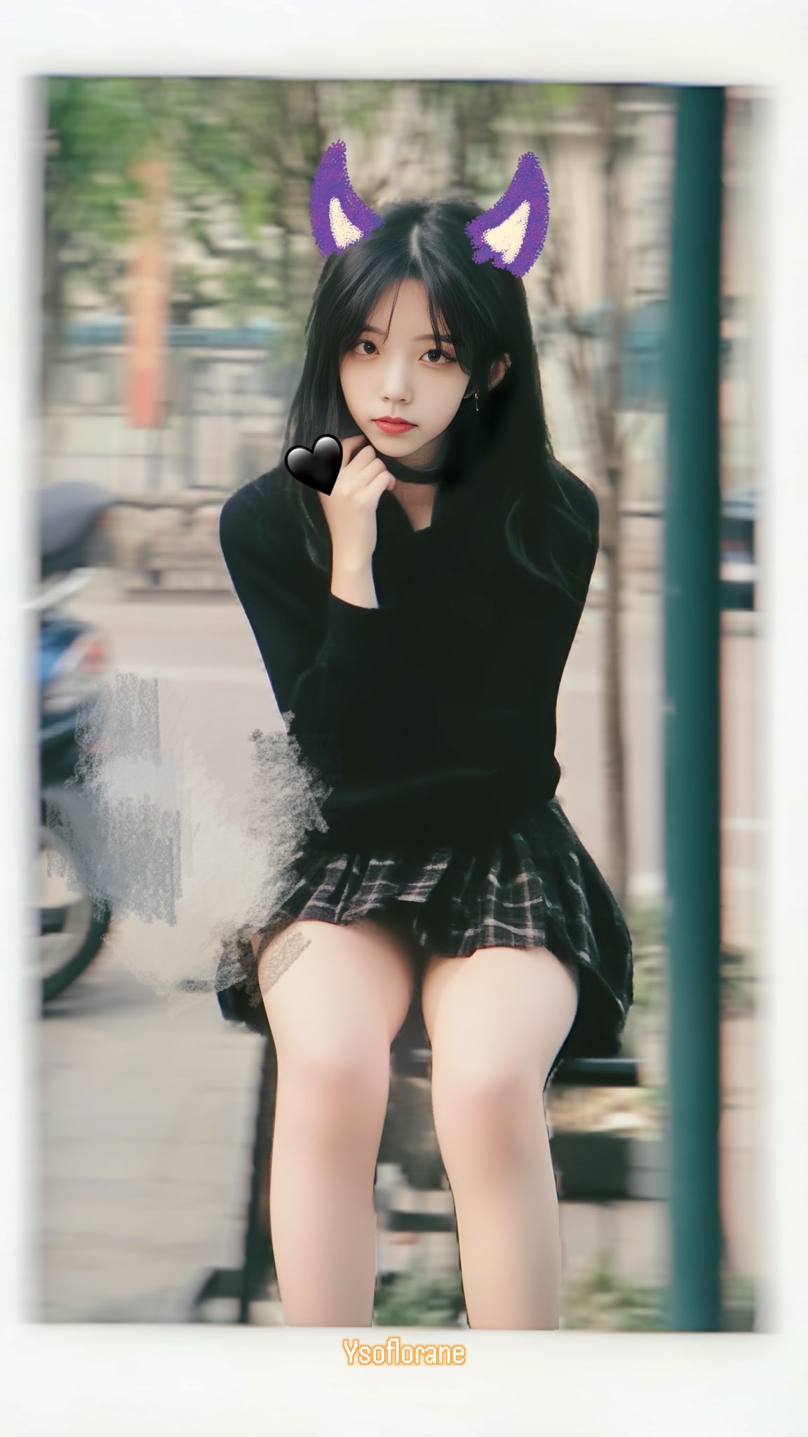 穿着黑色衬衫和黑色裙子的女孩坐在一个凳子上。