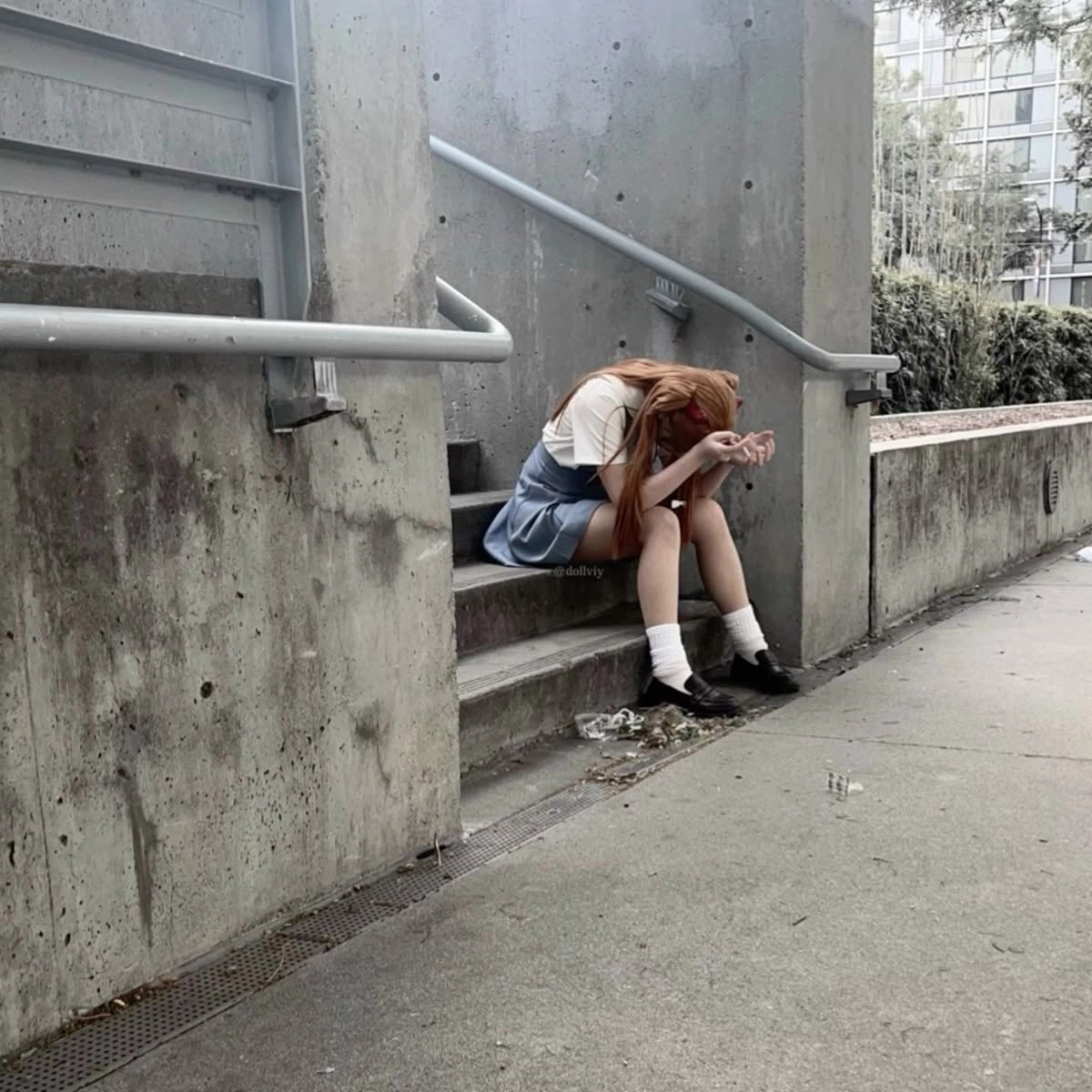 女孩坐在建筑物的楼梯上。