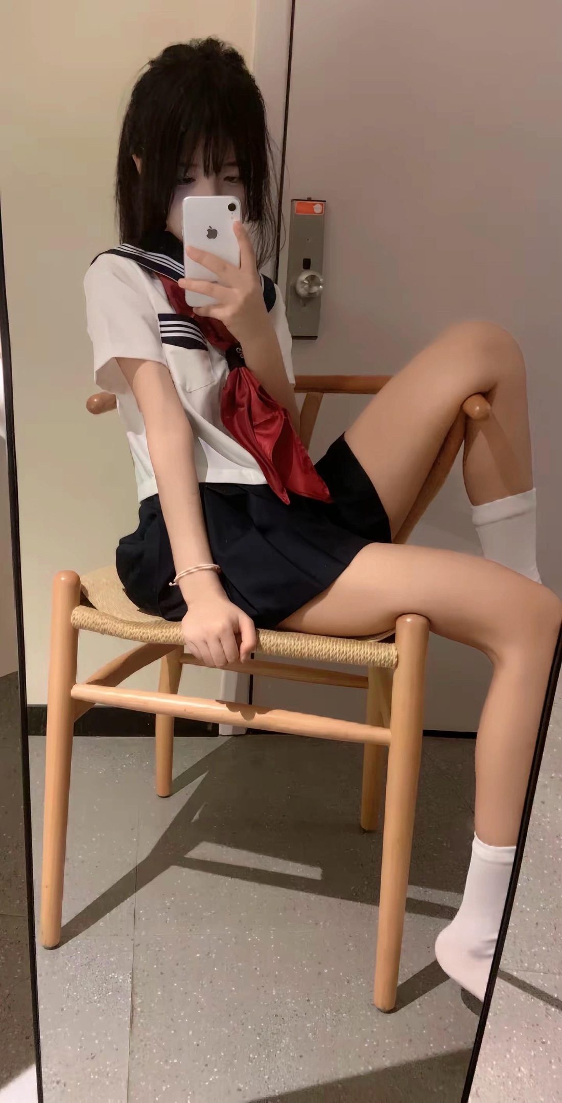 穿着白色衬衫和红色领带的女人坐在椅子上。