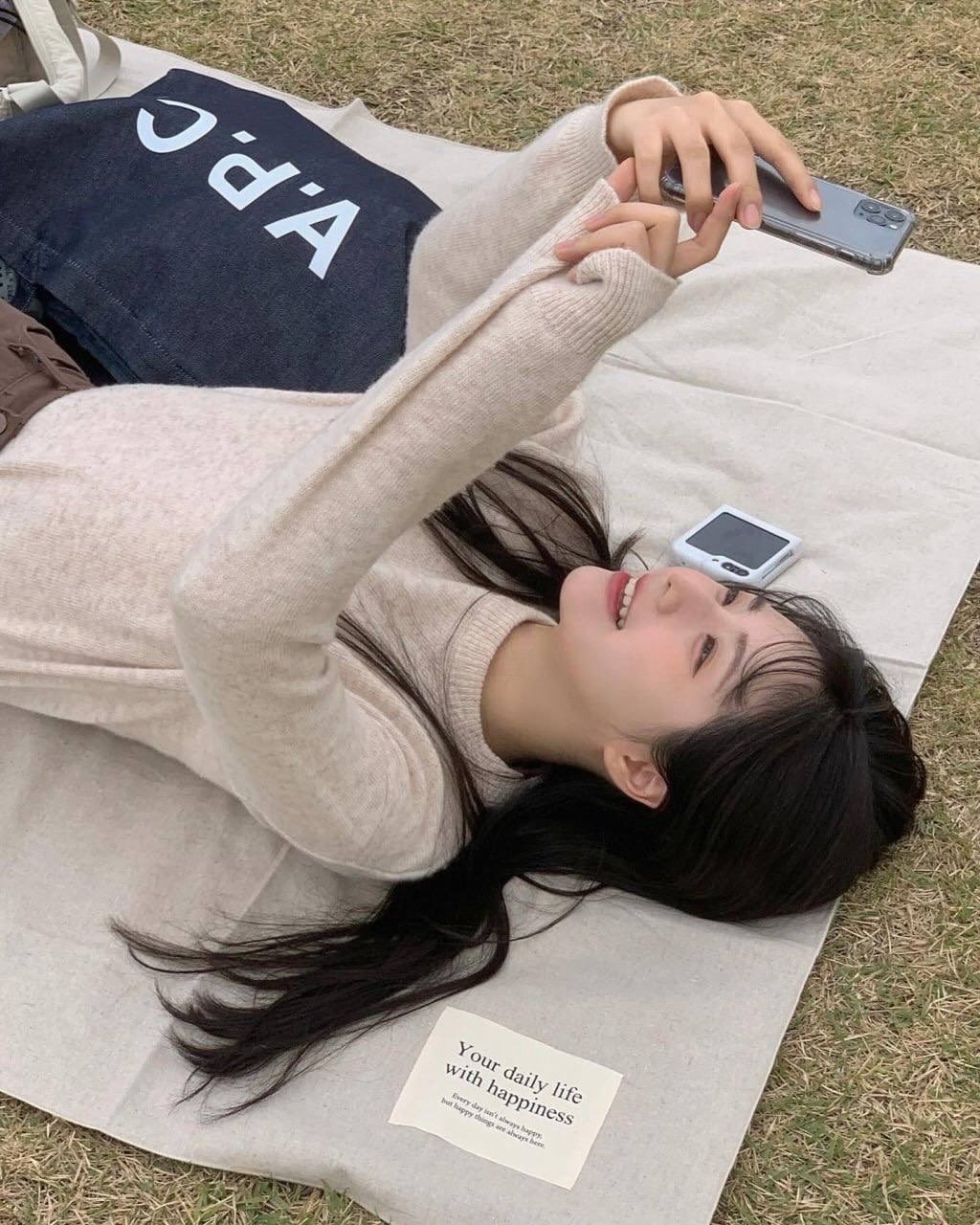 穿着白色衬衫和黑色鞋子的女人躺在草地上。