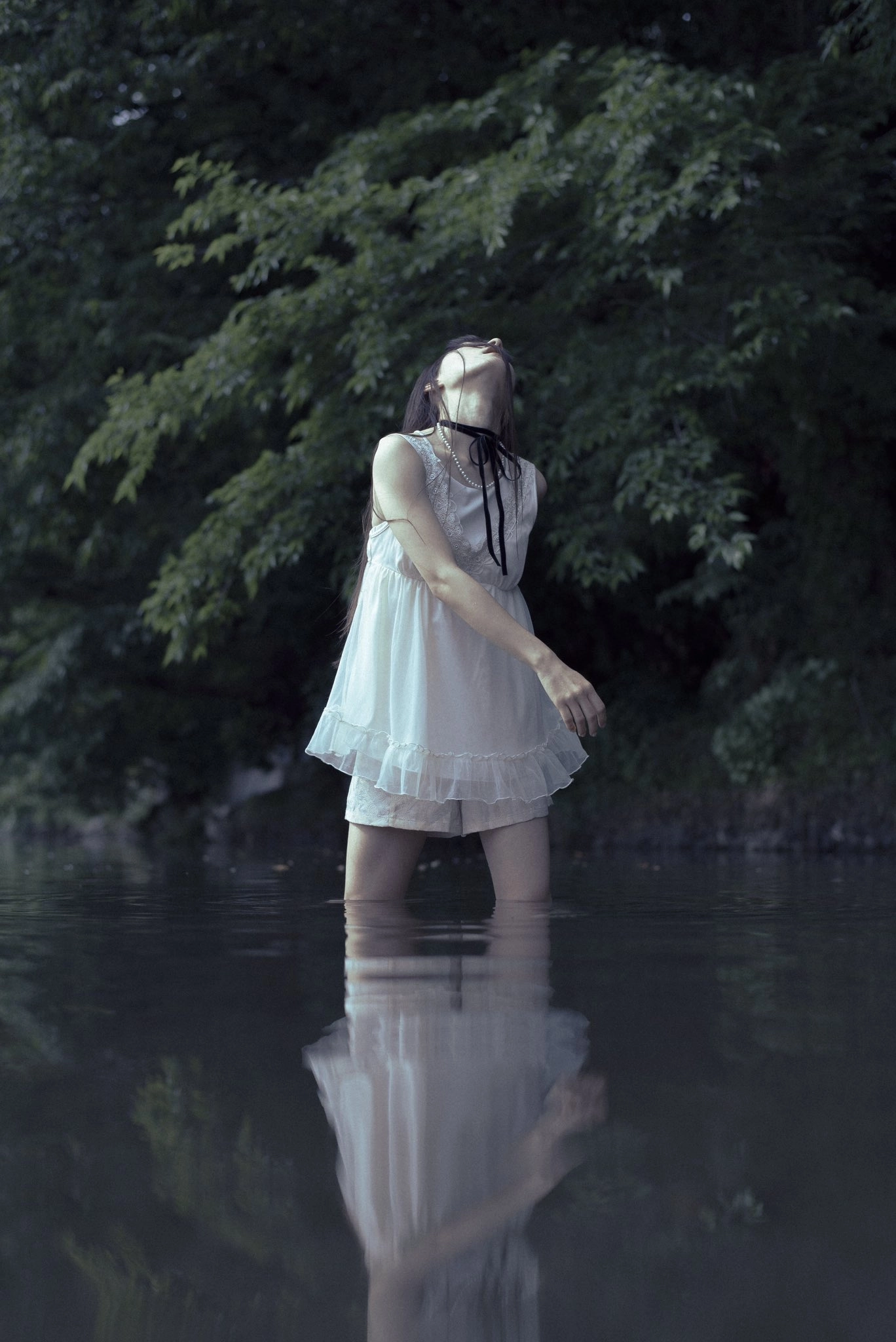 穿着白色衣服的女人站在水中。