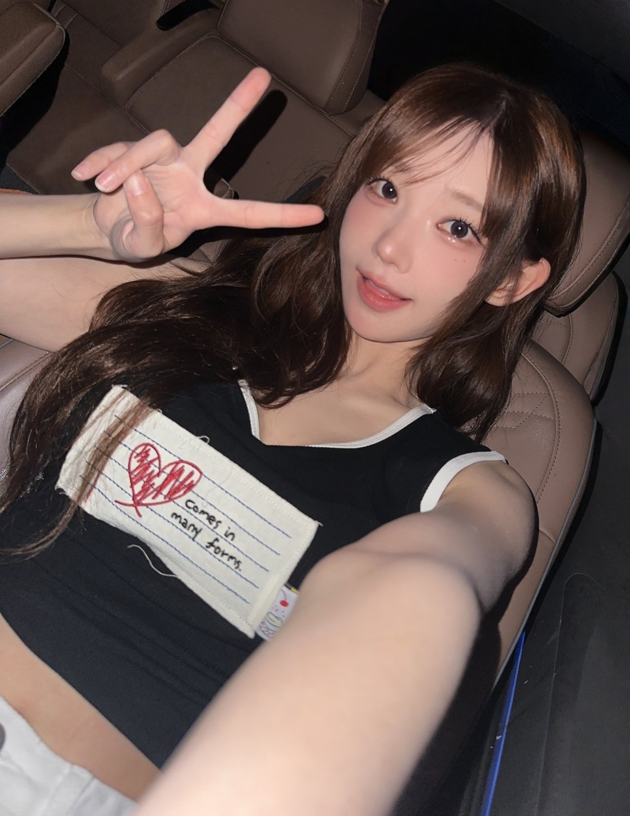 穿着黑色衬衫的女孩正在做一个和平的信号。