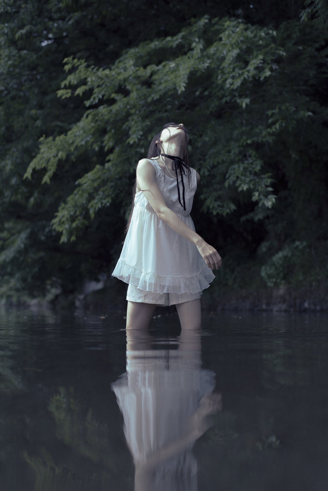 穿着白色衣服的女人站在水中。