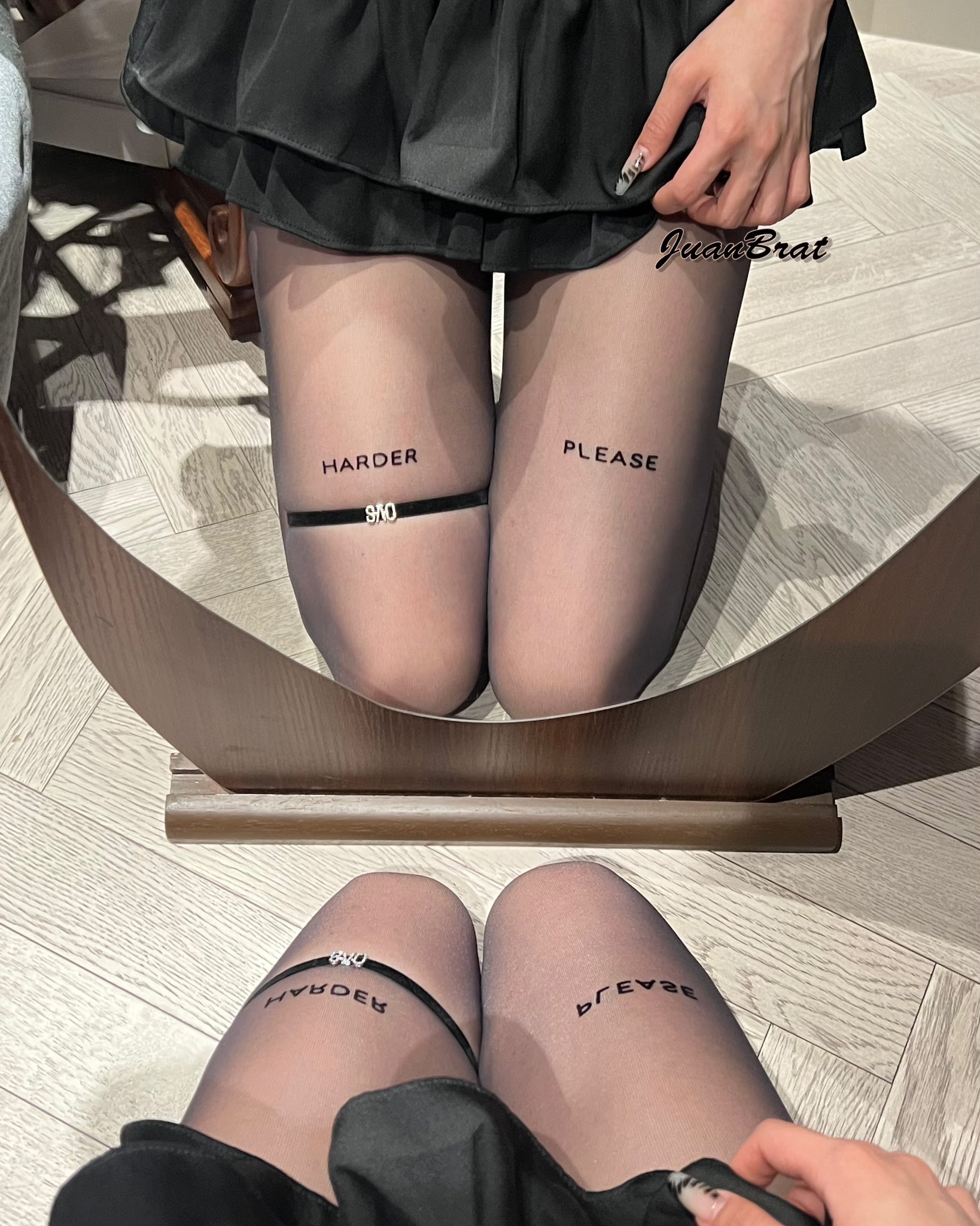 一位穿着黑色袜子和黑色裙子的女人,脚上写着“请加紧”的字。