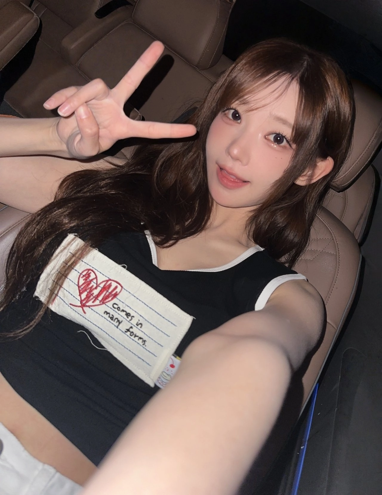 穿着黑色衬衫的女孩正在做一个和平的信号。