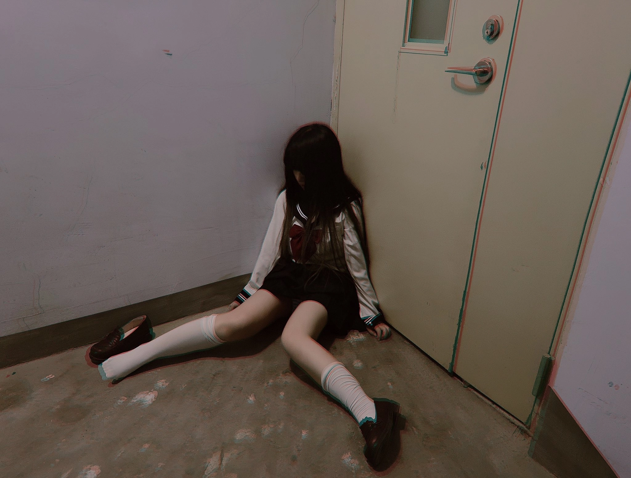 穿着校服的女孩坐在地板上。