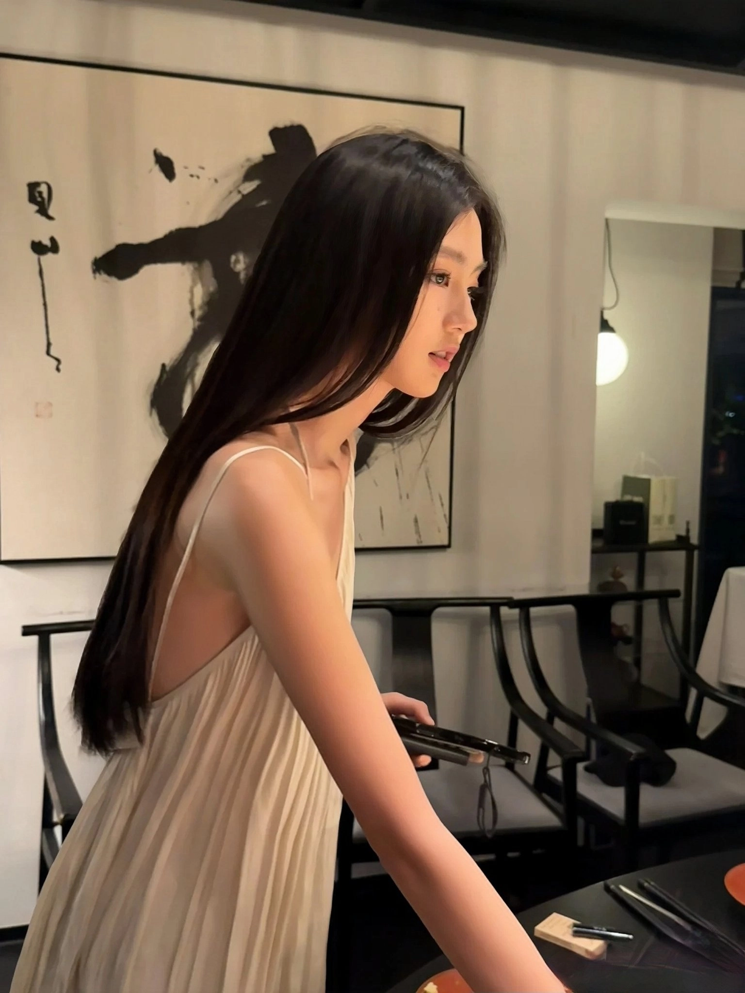 长头发和白色裙子的女人拿着头发刷。