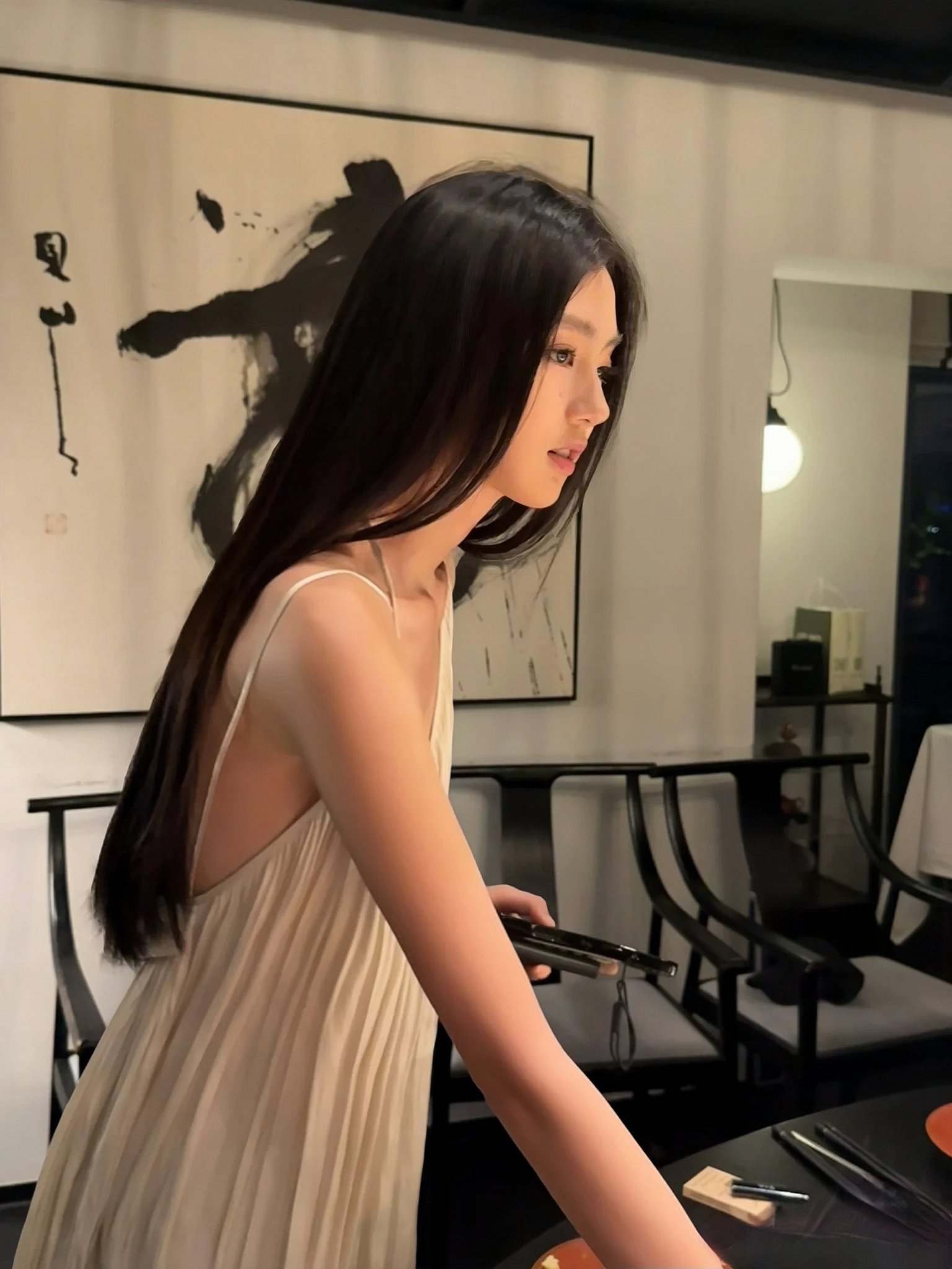 长头发和白色裙子的女人拿着头发刷。