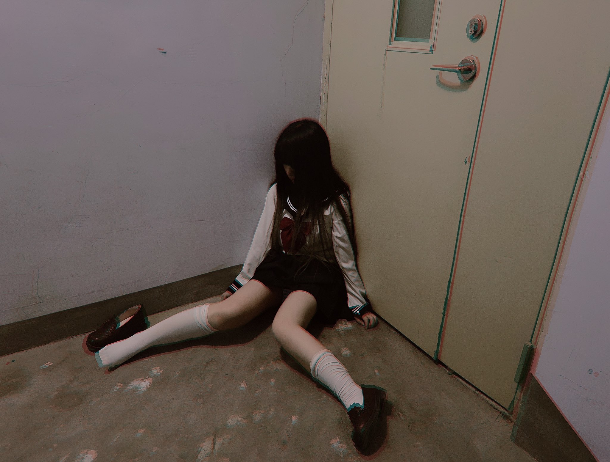 穿着校服的女孩坐在地板上。