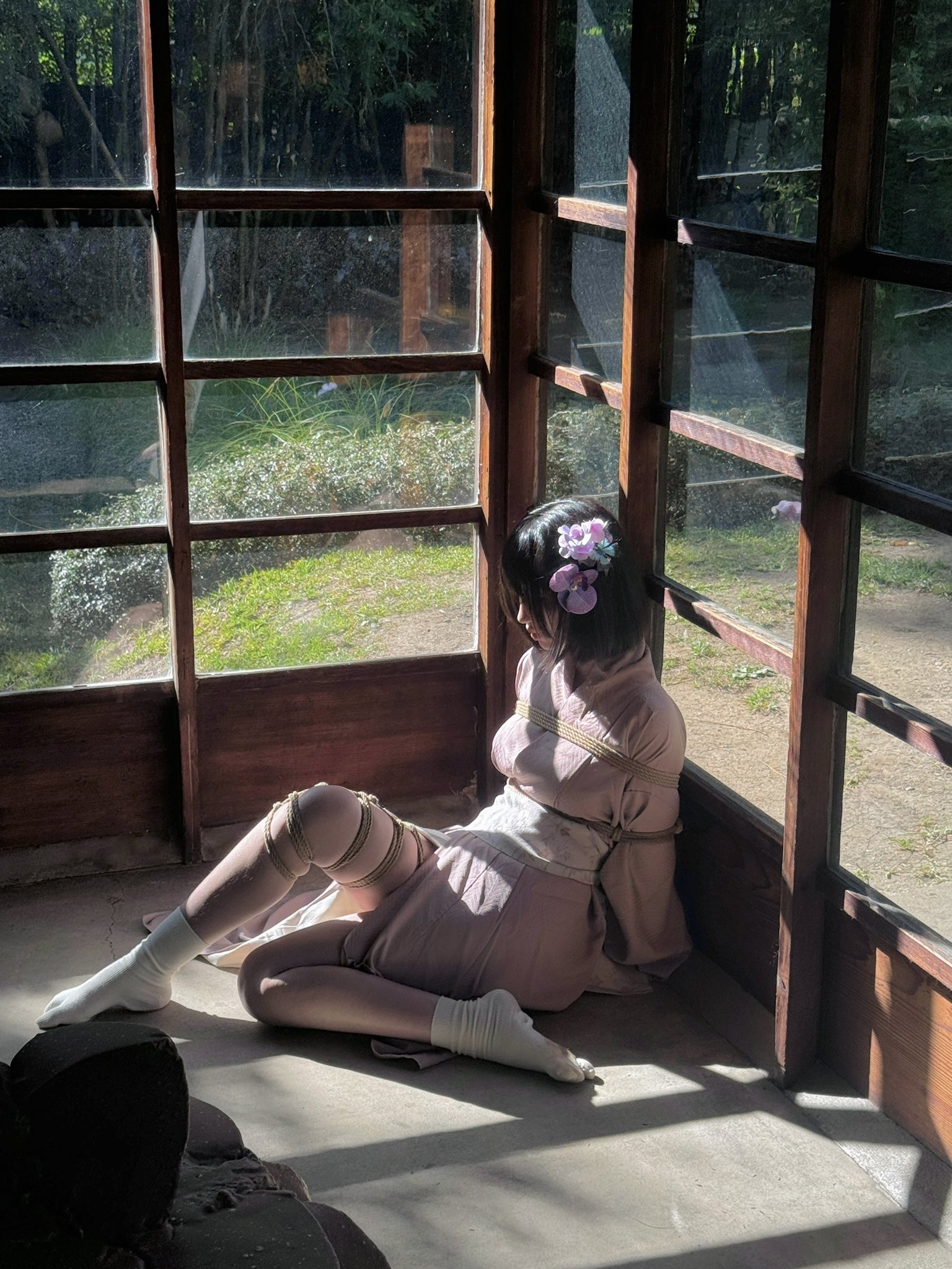 女人被绑起来,坐在地板上。