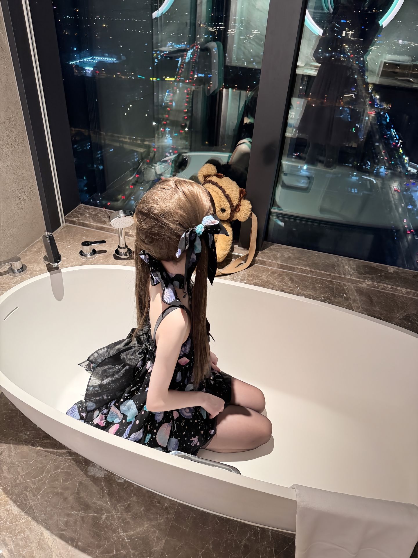 女孩在浴缸里,她的头发里有蓝色弓。