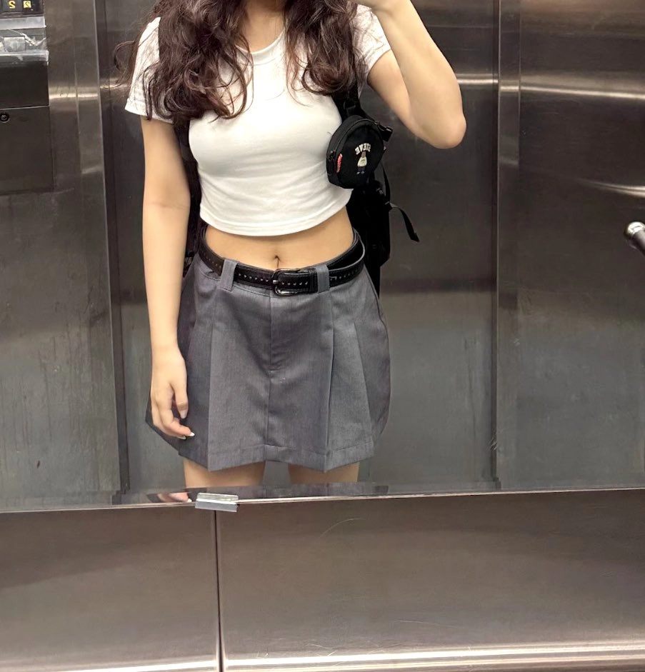 穿着裙子和白衬衫的女人拍了一张自拍。