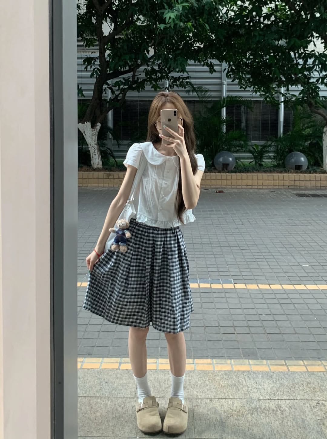 女人在一棵树前拍自拍。