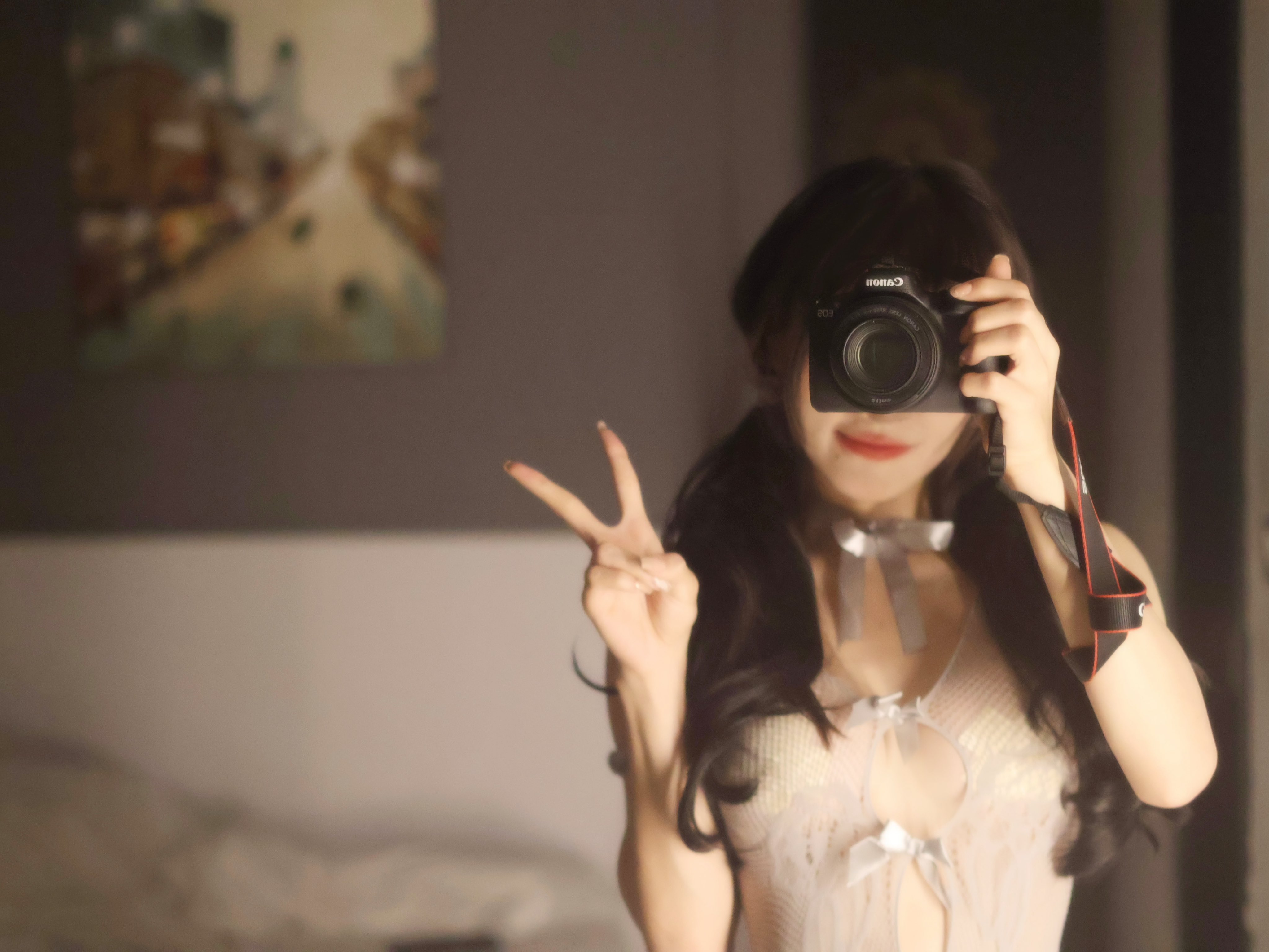 一位穿着白色衣服的女人拿着相机,发出和平的信号。