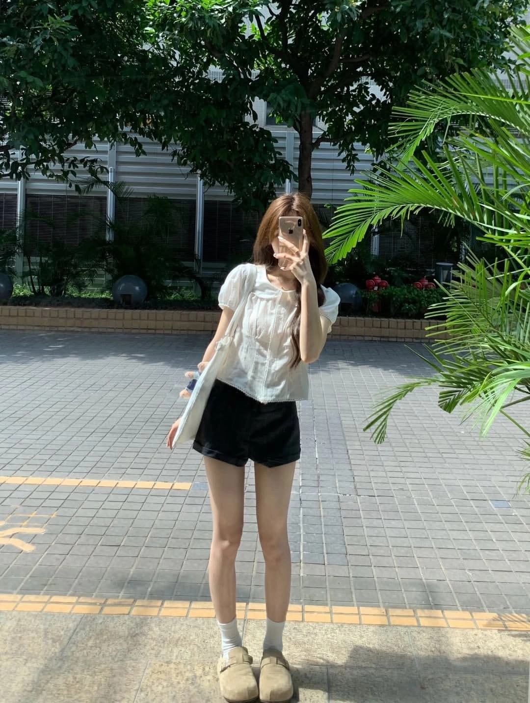 女人在一棵树前拍自拍。