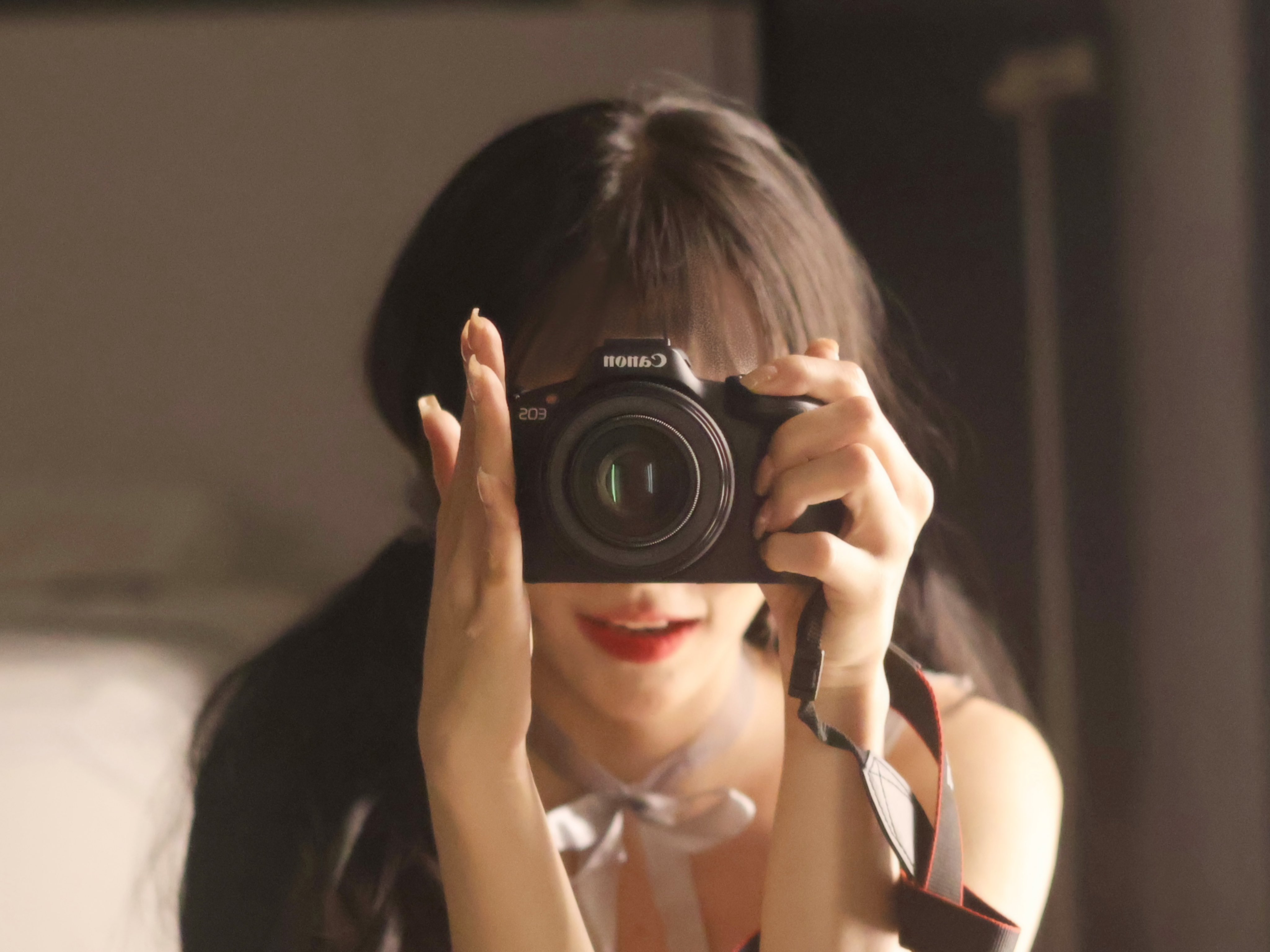 一位穿着白色衣服的女人拿着相机,发出和平的信号。