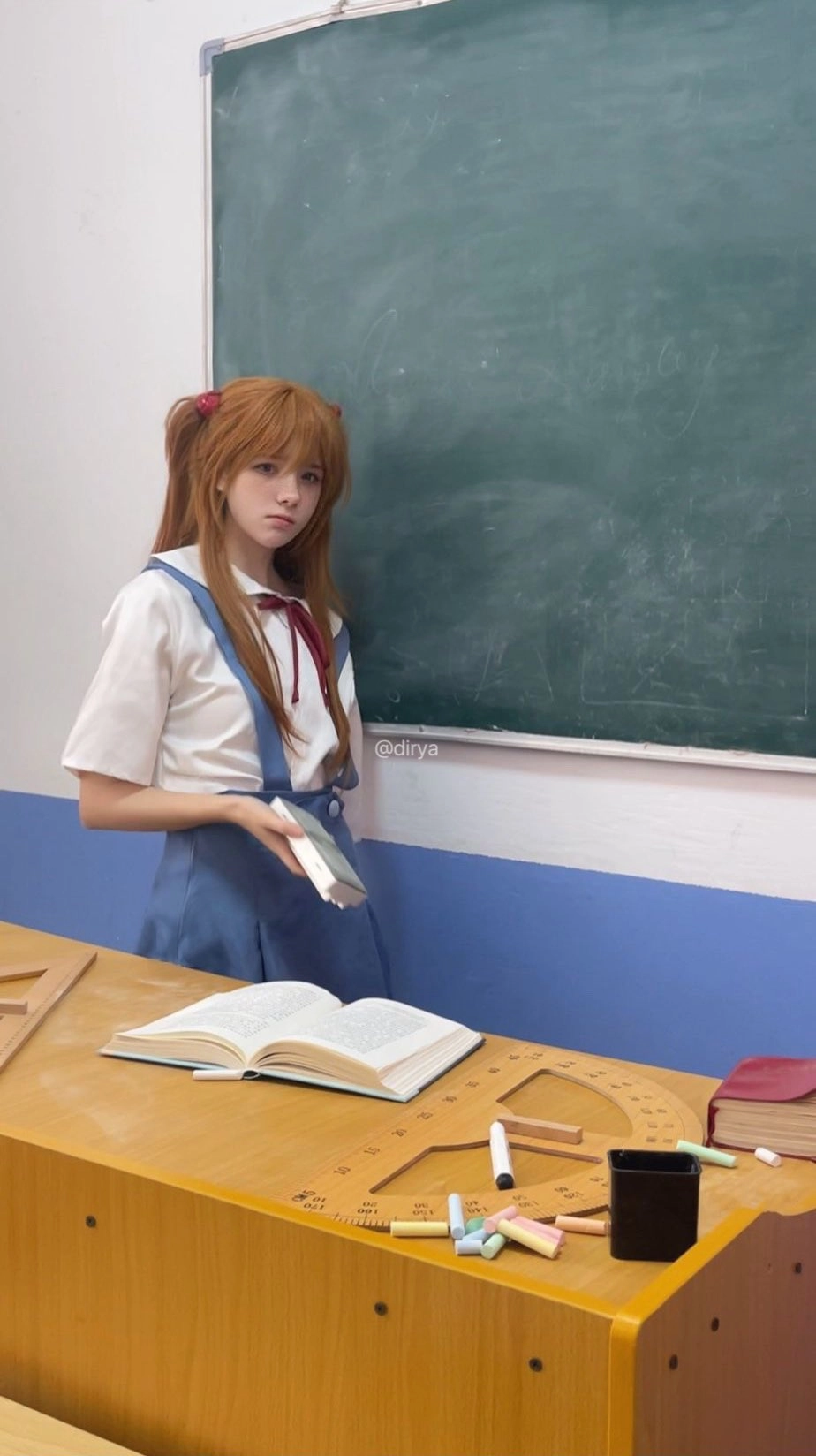 女孩带着一本书在一张纸板前面。