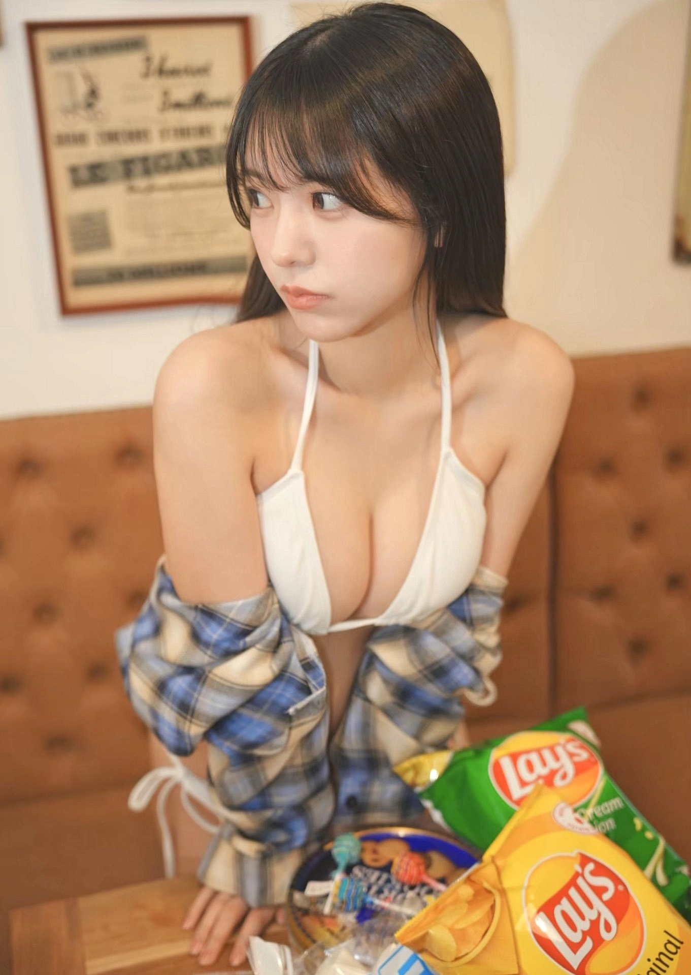 穿着白色比基尼顶的女人拿着一袋芯片。