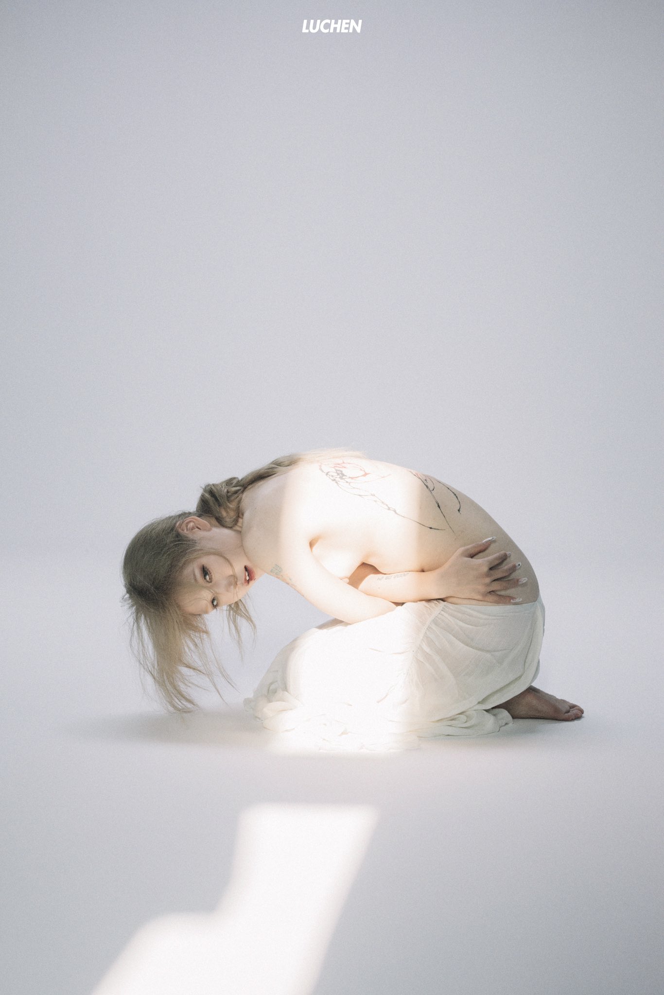 女人的纹身坐在地板上。