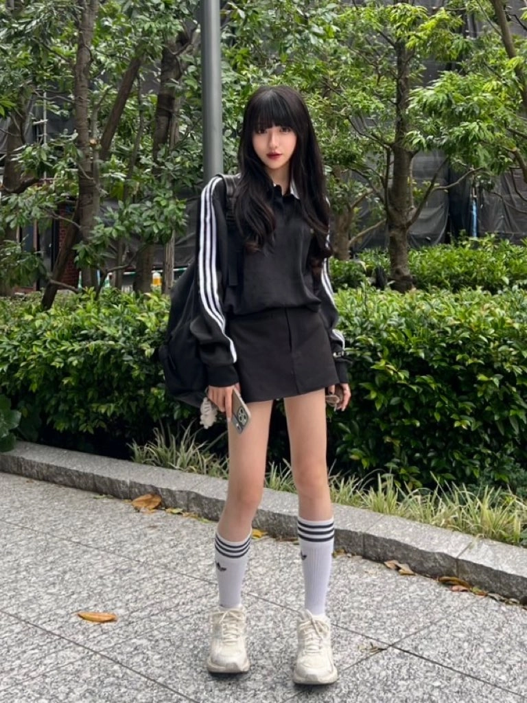 一位穿着黑色衬衫和白色袜子的女人站在走廊上。