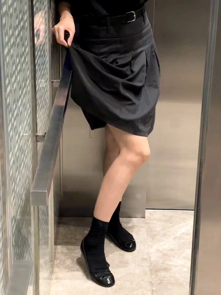 一位穿着黑色衣服的女人站在电梯里。