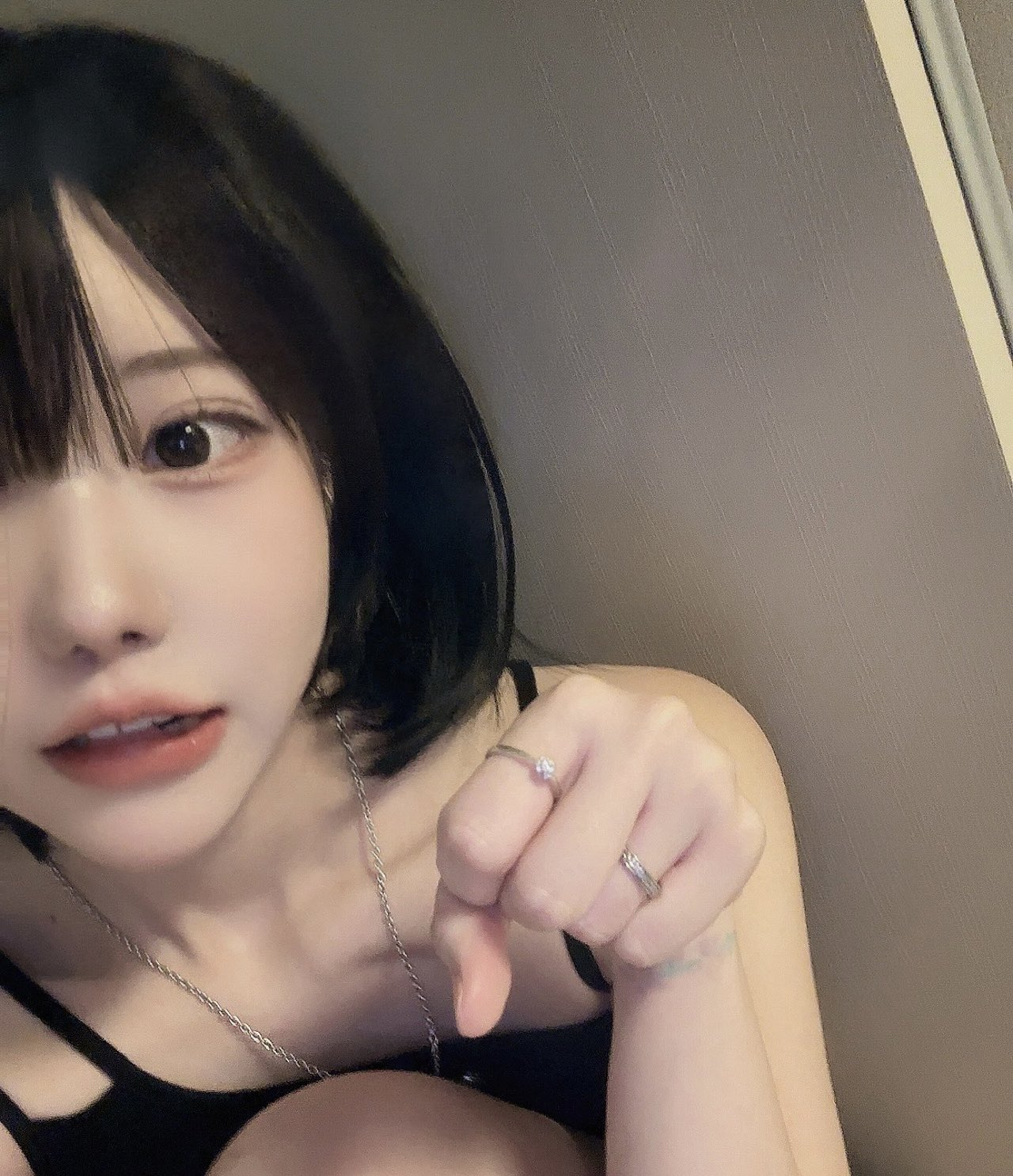 黑头发和手指上的戒指的女人正在做一个脚手势。