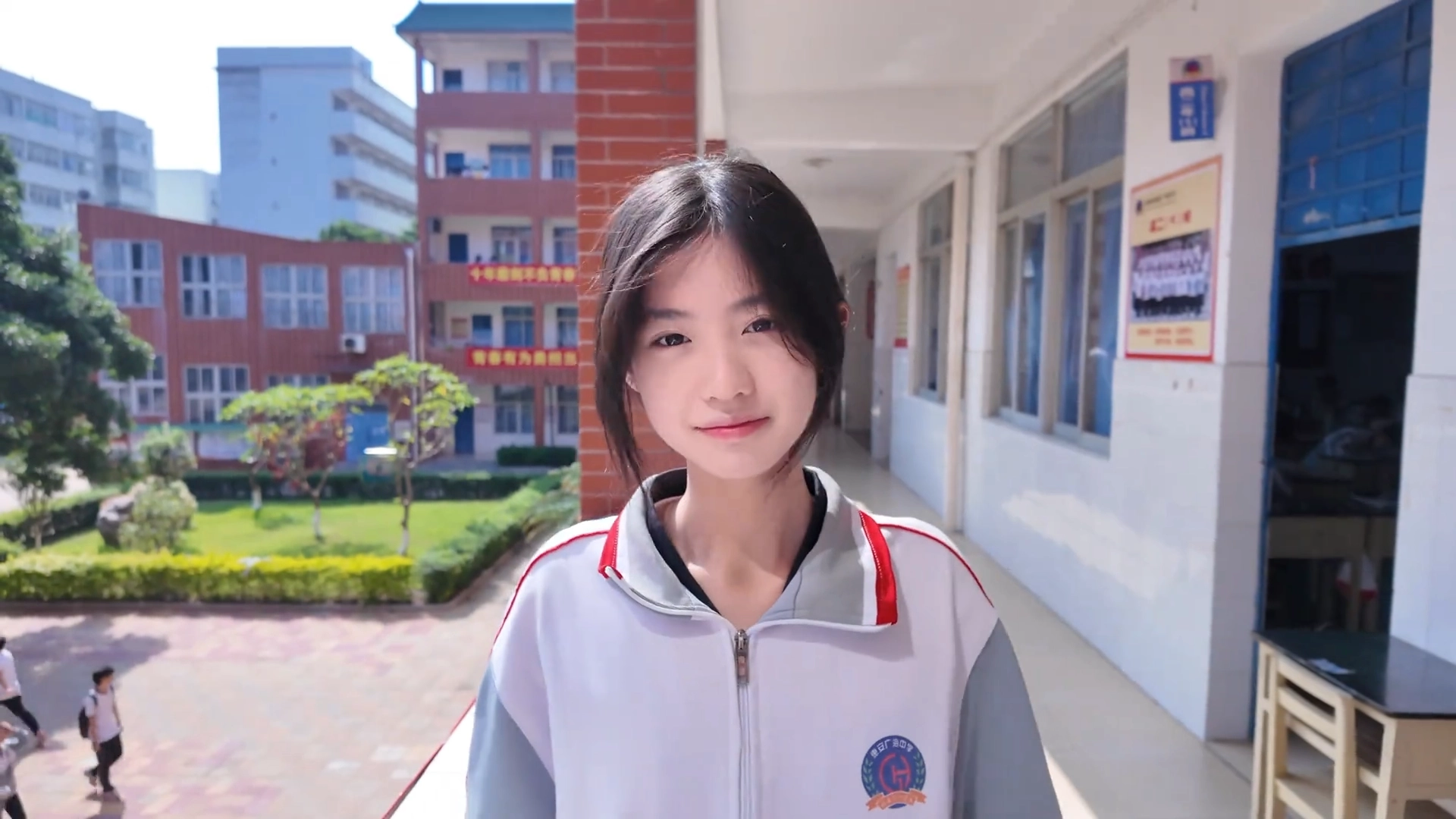 一位穿着白色外套和红色外套的年轻女子对相机微笑。