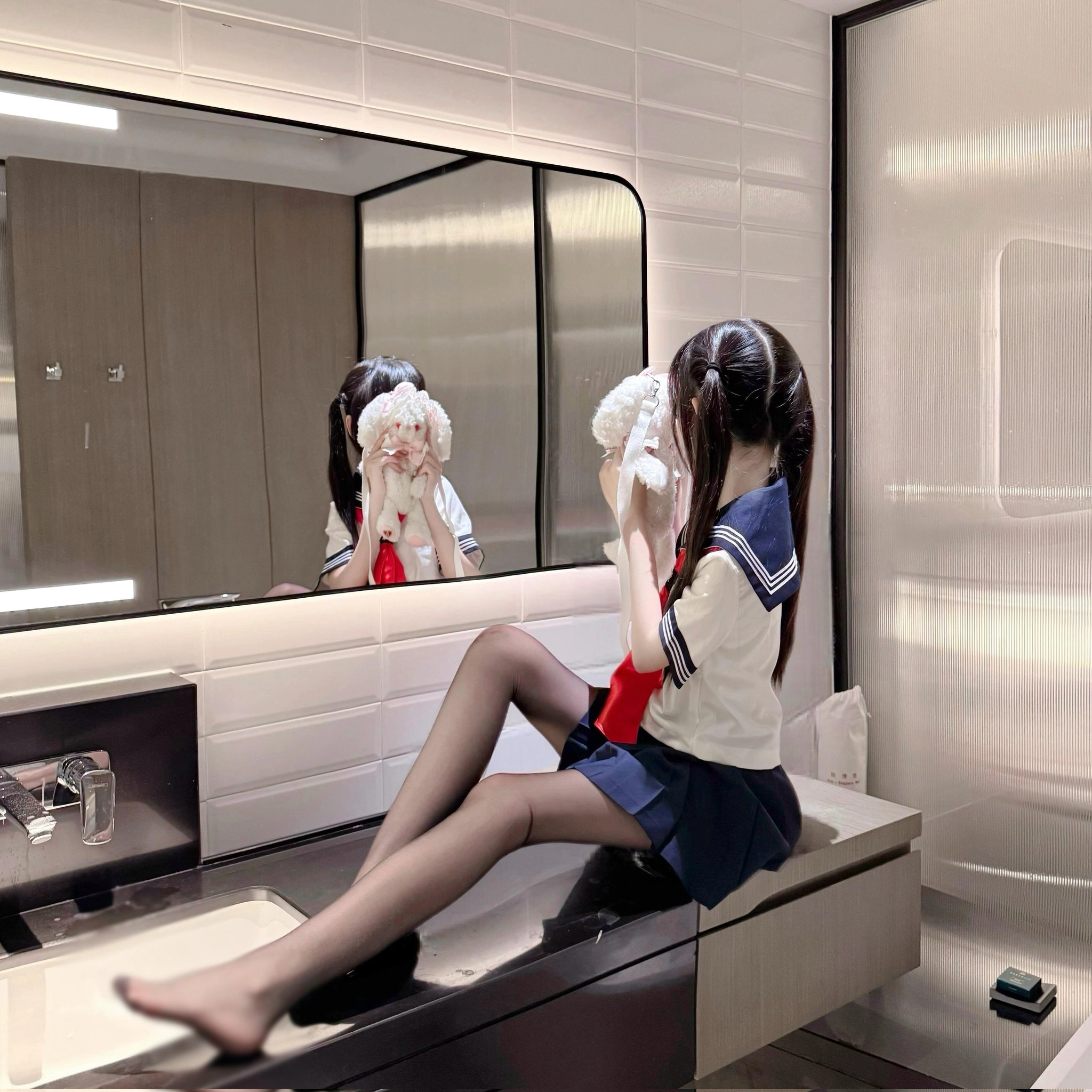 戴着蓝色水手帽子的女孩坐在镜子前。