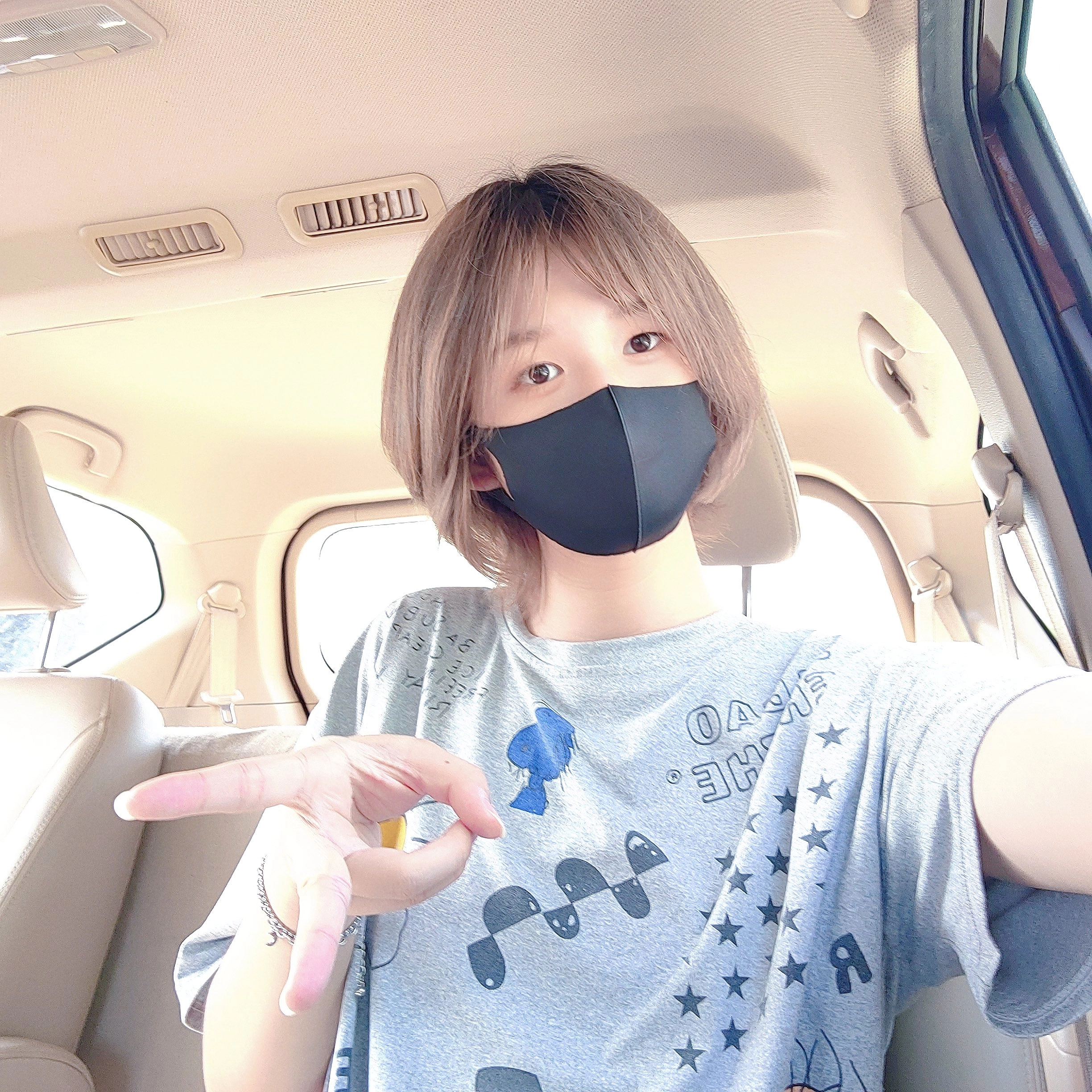 戴着黑面具和灰色衬衫的女人。