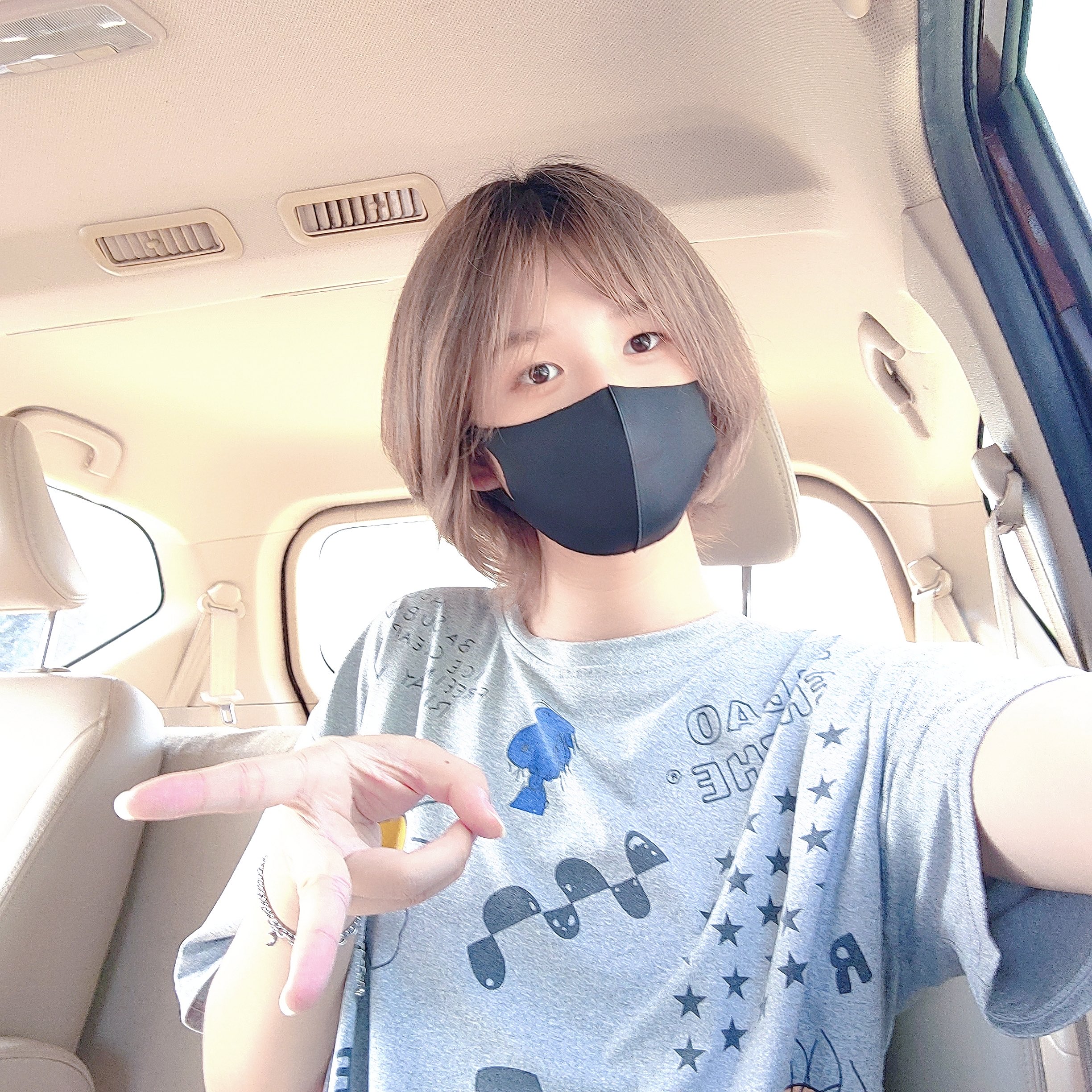 戴着黑面具和灰色衬衫的女人。