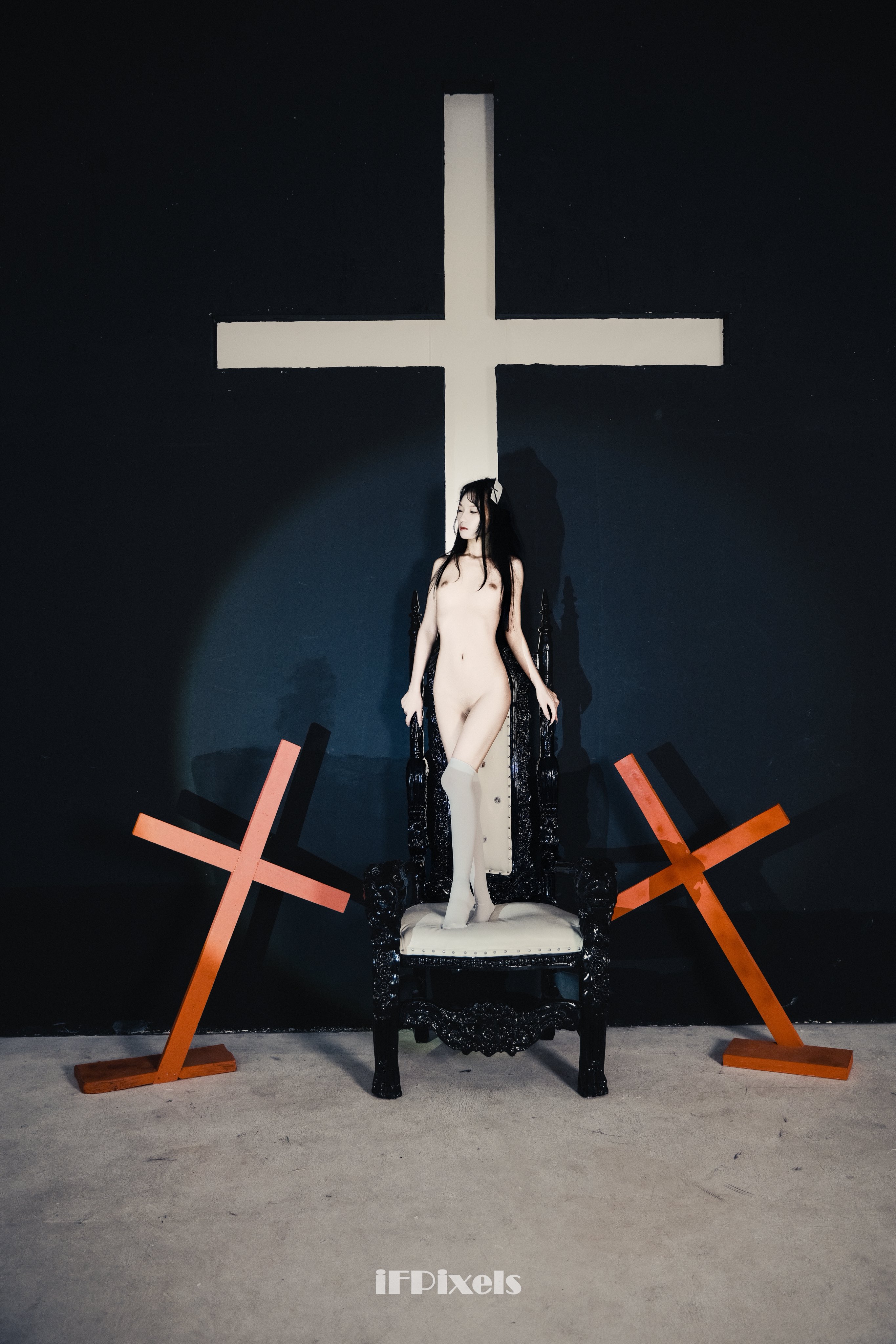 女人坐在椅子上,她面前有一个十字架。