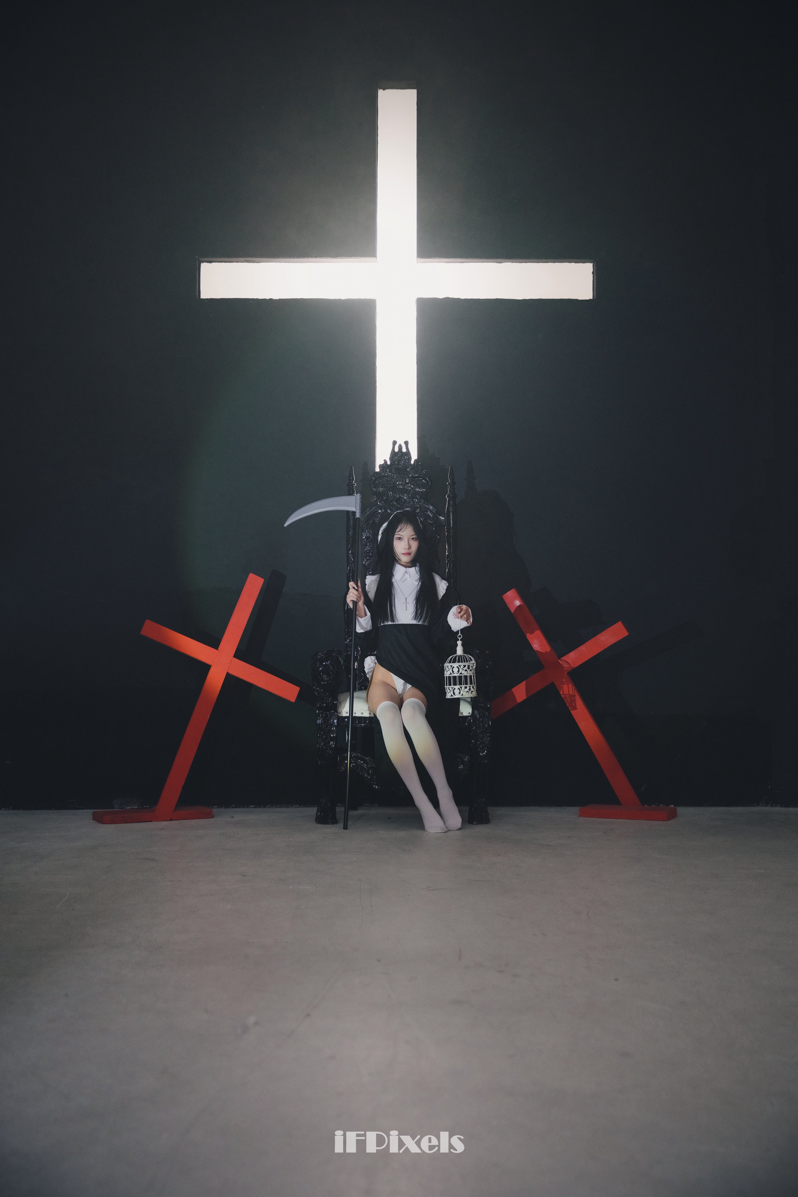 女人坐在椅子上,她面前有一个十字架。