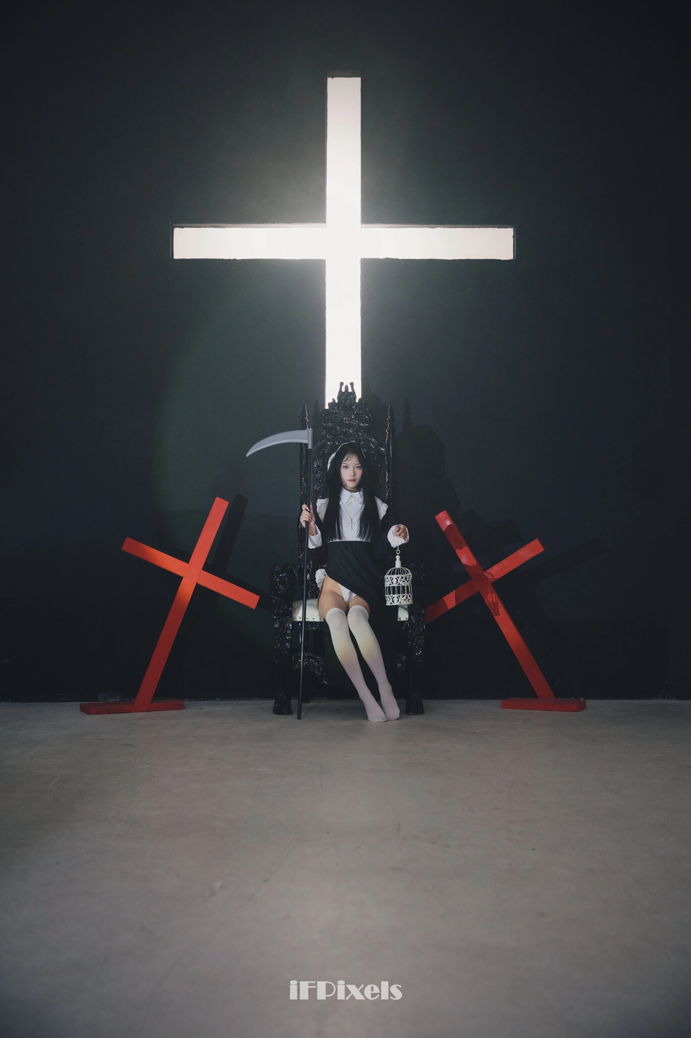 女人坐在椅子上,她面前有一个十字架。