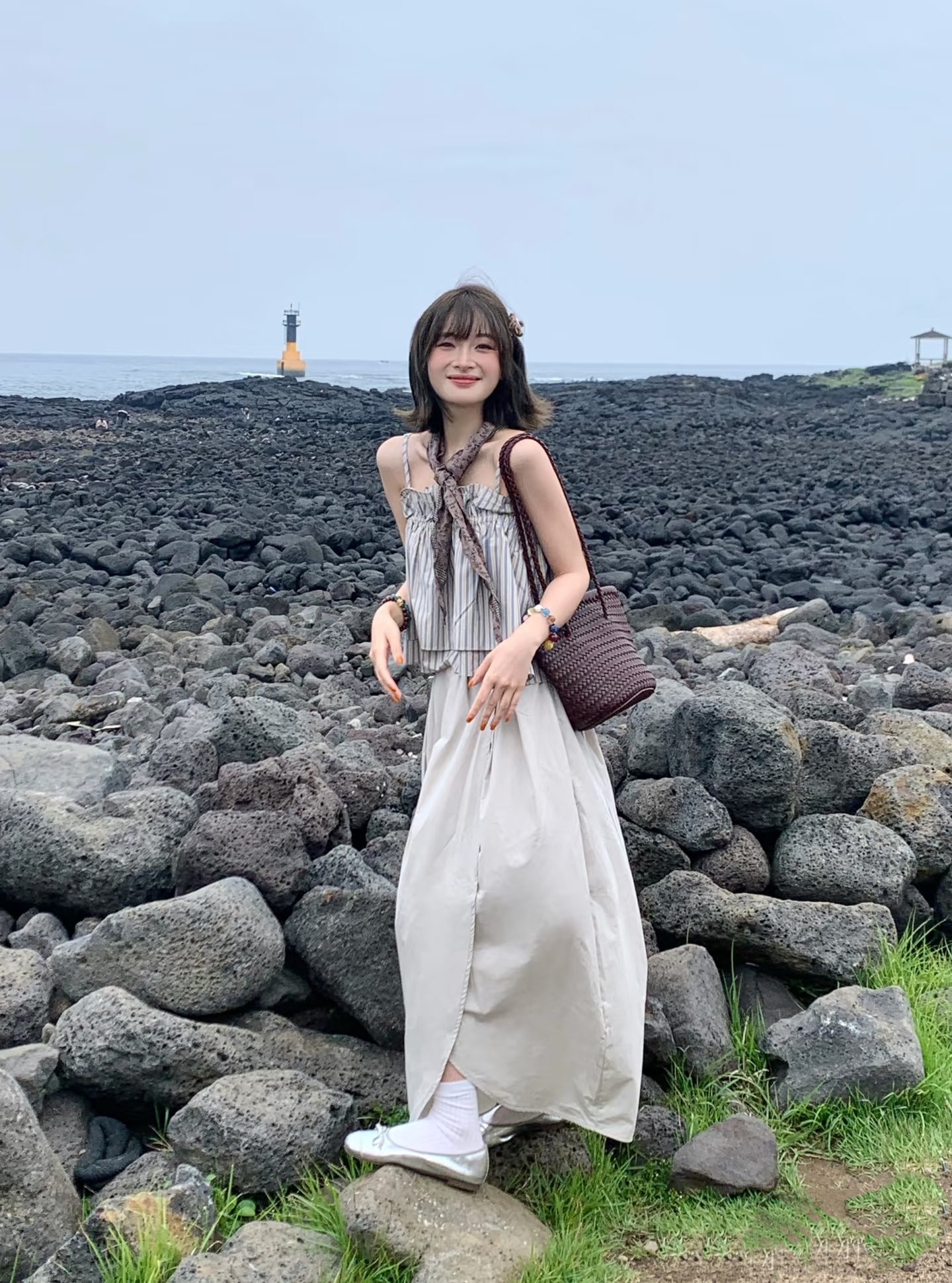 女人穿着白色裙子,带着棕色钱包。