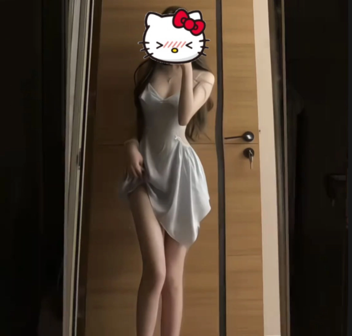 女人穿着一个白色的裙子和一个Hello Kitty贴纸在她的头上。