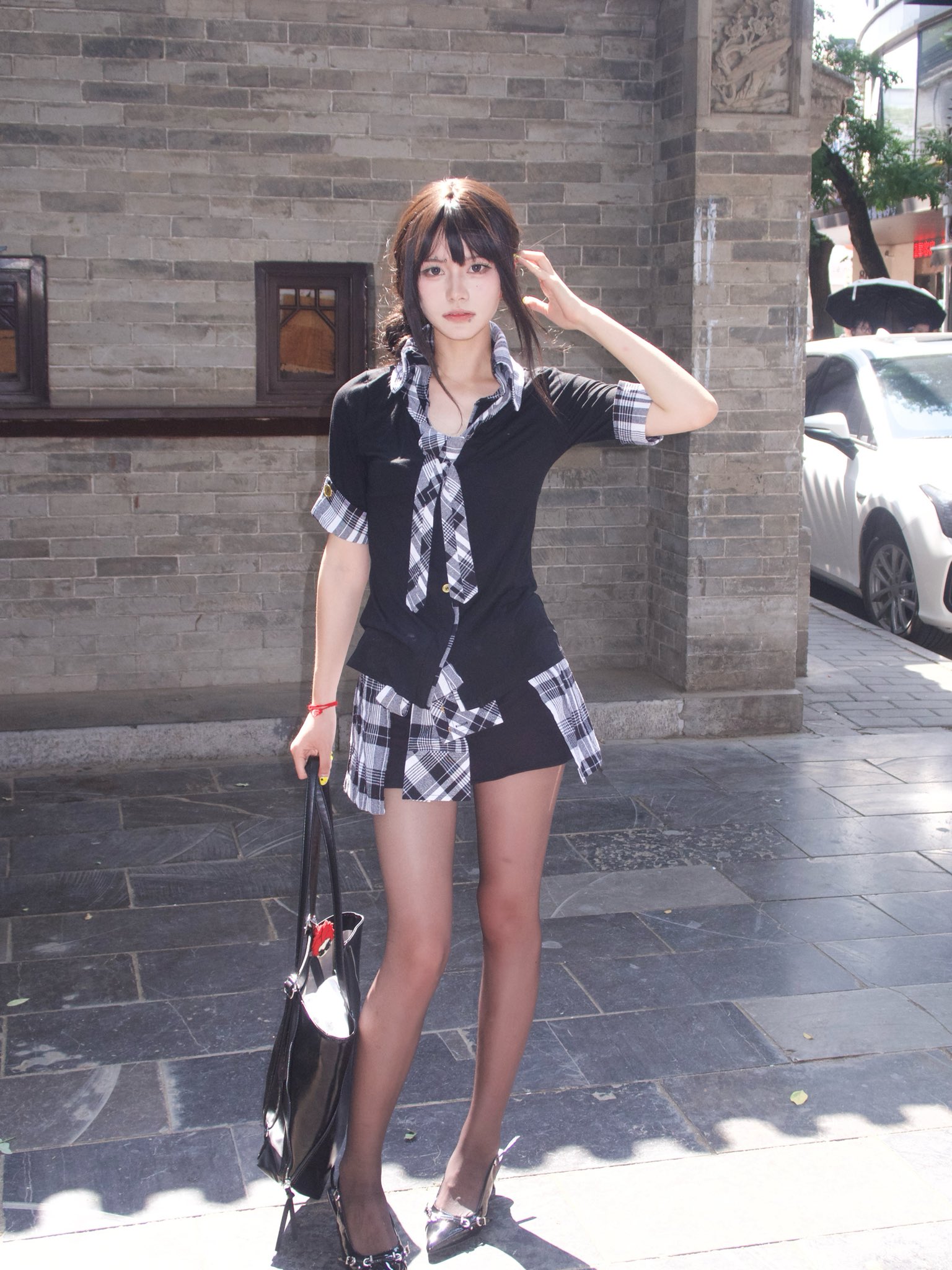 穿着黑色衬衫和黑色短裤的女人,有一个检查的模式。