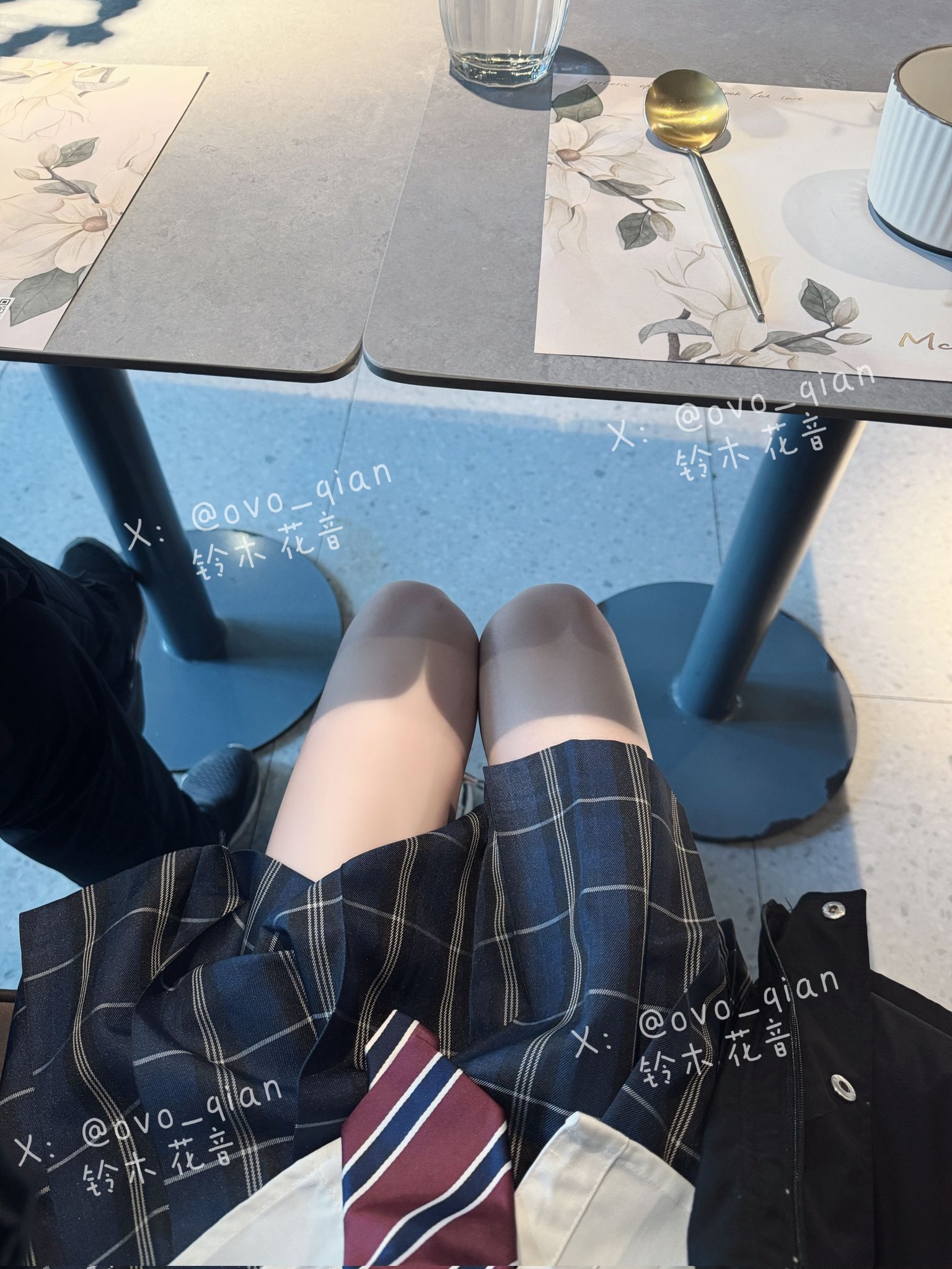 女人穿着一件的裙子和一件领带坐在一张桌子上。