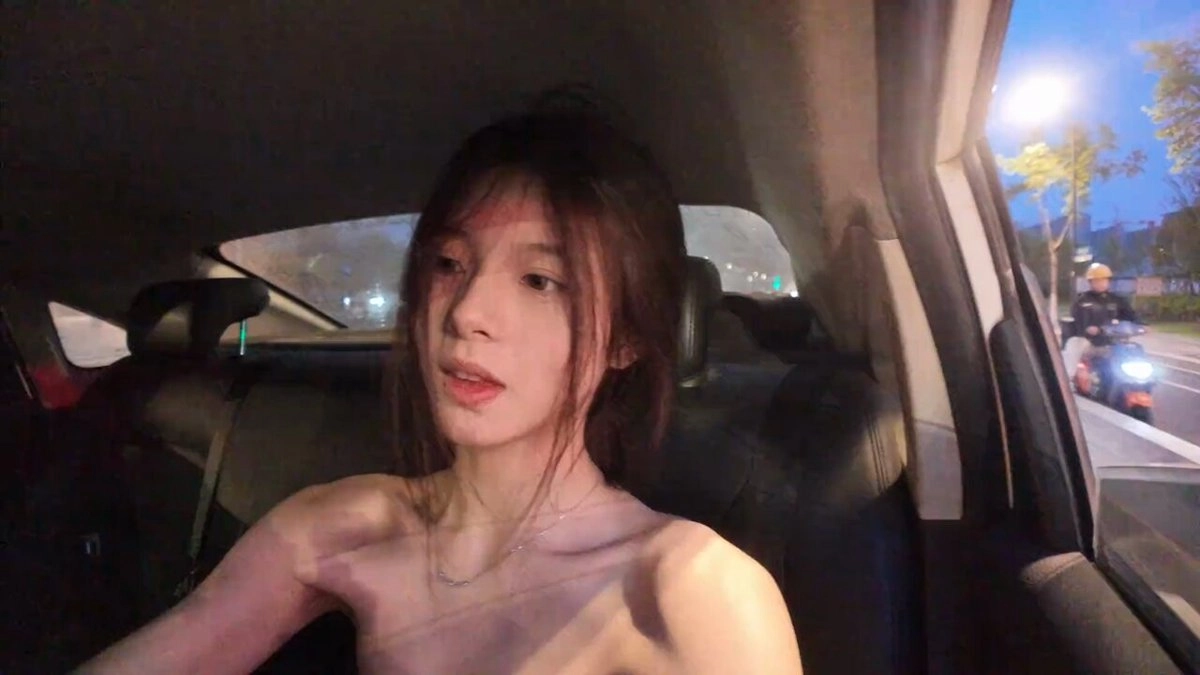 长头发和项链的女人坐在车里。