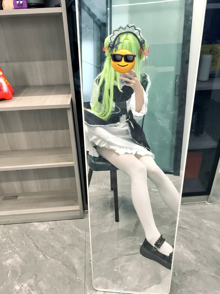 穿着绿色衣服的女孩坐在床上。