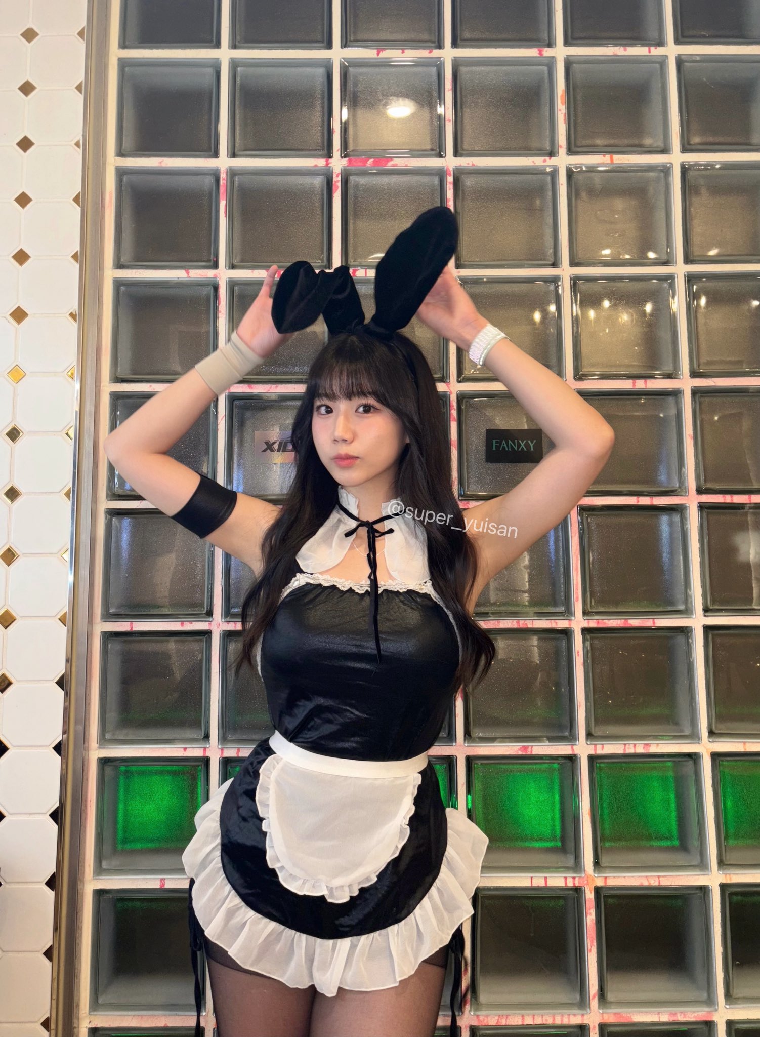 穿着黑色裙子和兔子耳朵的女人为一张照片。